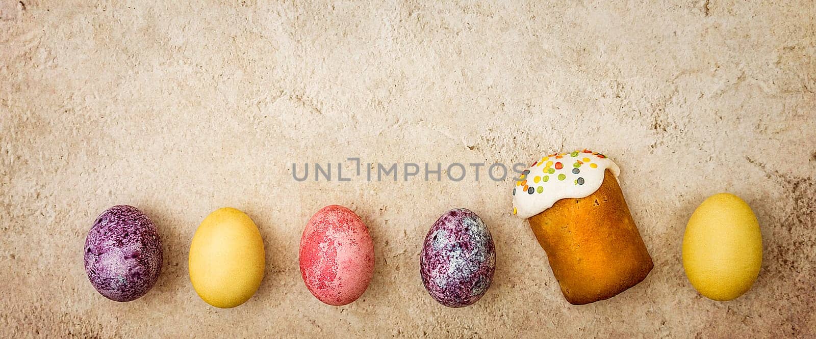Easter cakes and Easter colored eggs on a beautiful textured background. Religious holiday of bright Easter.