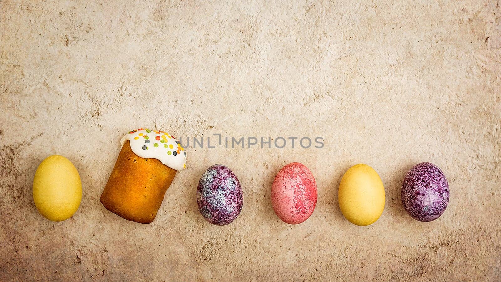 Easter cakes and Easter colored eggs on a beautiful textured background. Religious holiday of bright Easter.