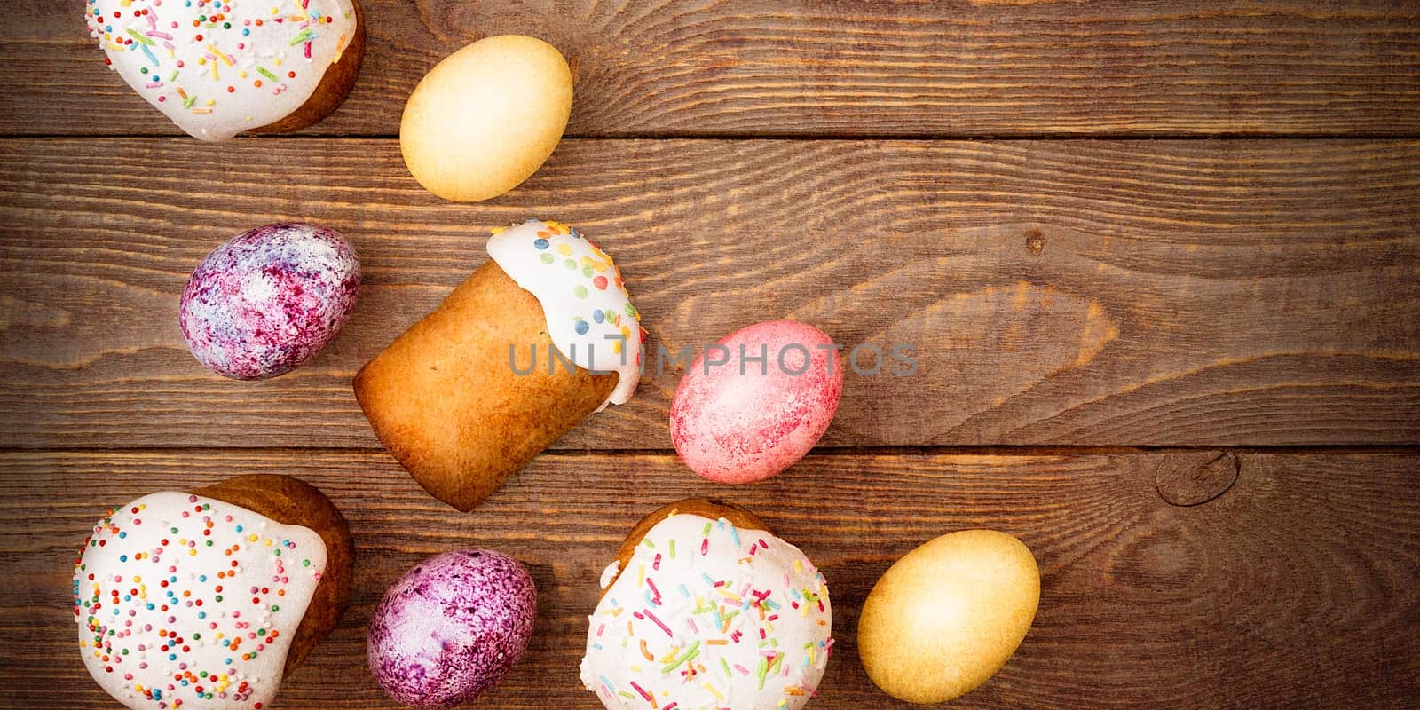 Easter cakes and Easter colored eggs on a wooden background. Religious holiday of bright Easter.