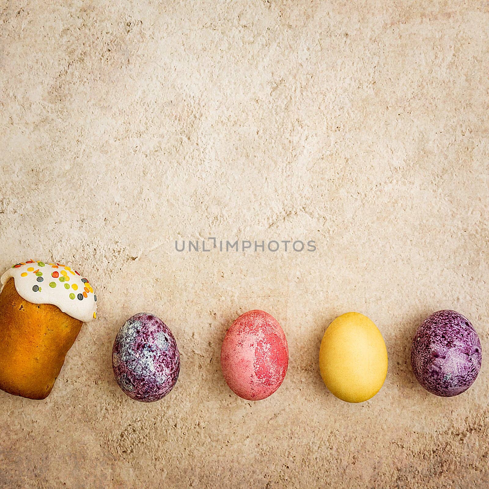 Easter cakes and Easter colored eggs on a beautiful textured background. Religious holiday of bright Easter.