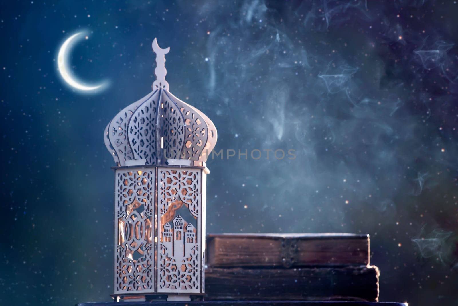 Ornamental Arabic lantern with crescent moon glowing at night. Festive greeting card for Muslim holy month Ramadan Kareem.
