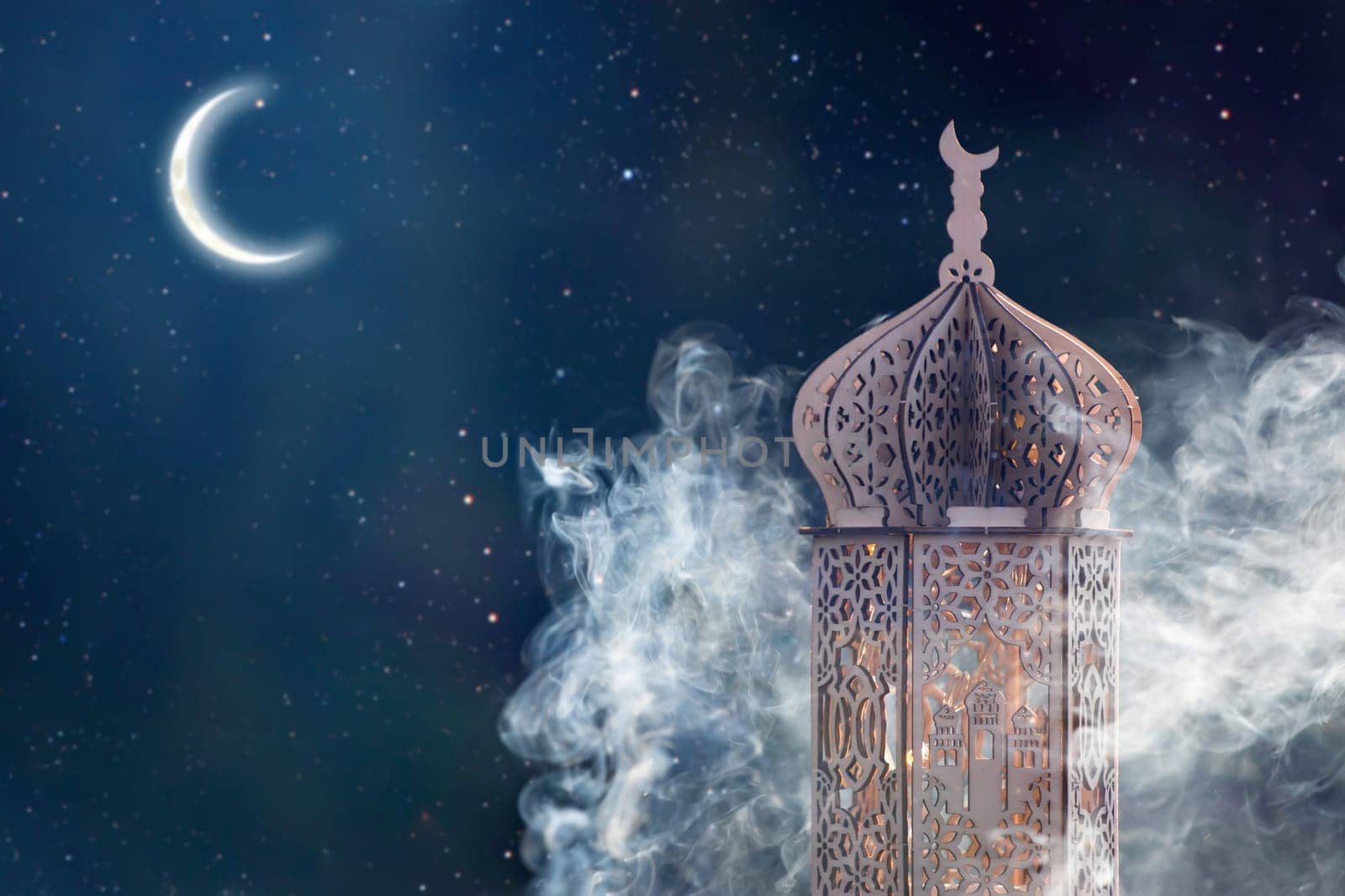 Ornamental Arabic lantern with crescent moon glowing at night. Festive greeting card for Muslim holy month Ramadan Kareem.