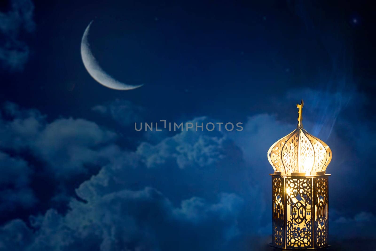 Ornamental Arabic lantern with crescent moon glowing at night. Festive greeting card for Muslim holy month Ramadan Kareem.