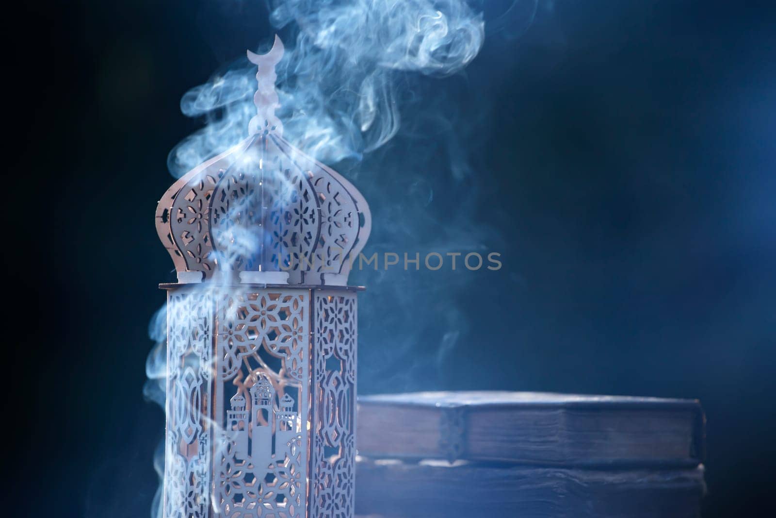 Ornamental Arabic lantern with with Holy Quran. Festive greeting card for Muslim holy month Ramadan Kareem.