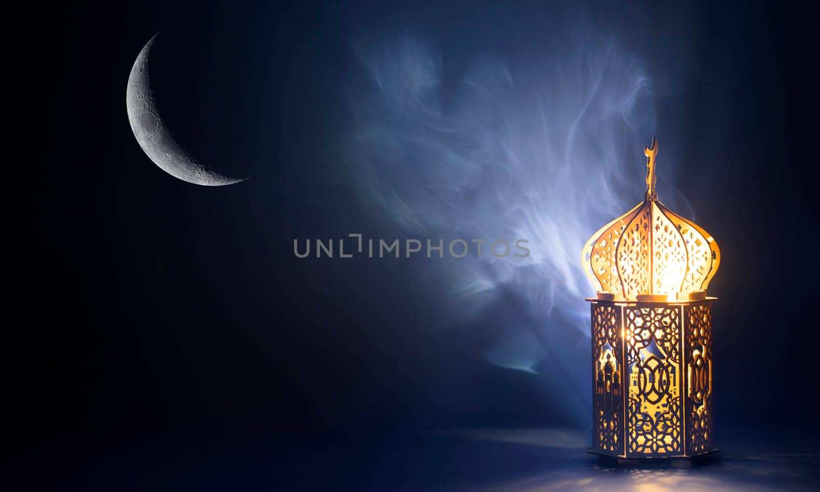 Ornamental Arabic lantern with crescent moon glowing at night. Festive greeting card for Muslim holy month Ramadan Kareem.