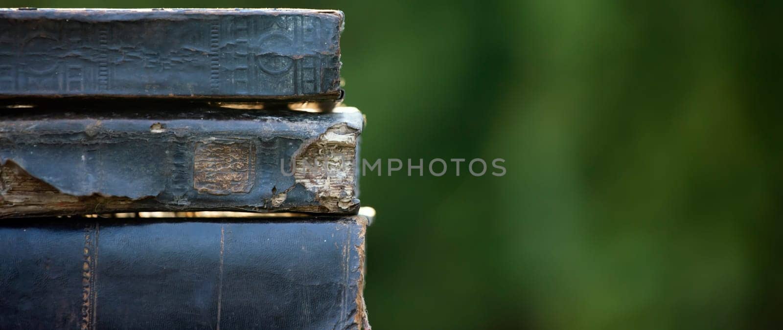 Literature, reading concept: banner or header image with stack of antique books against a dark background