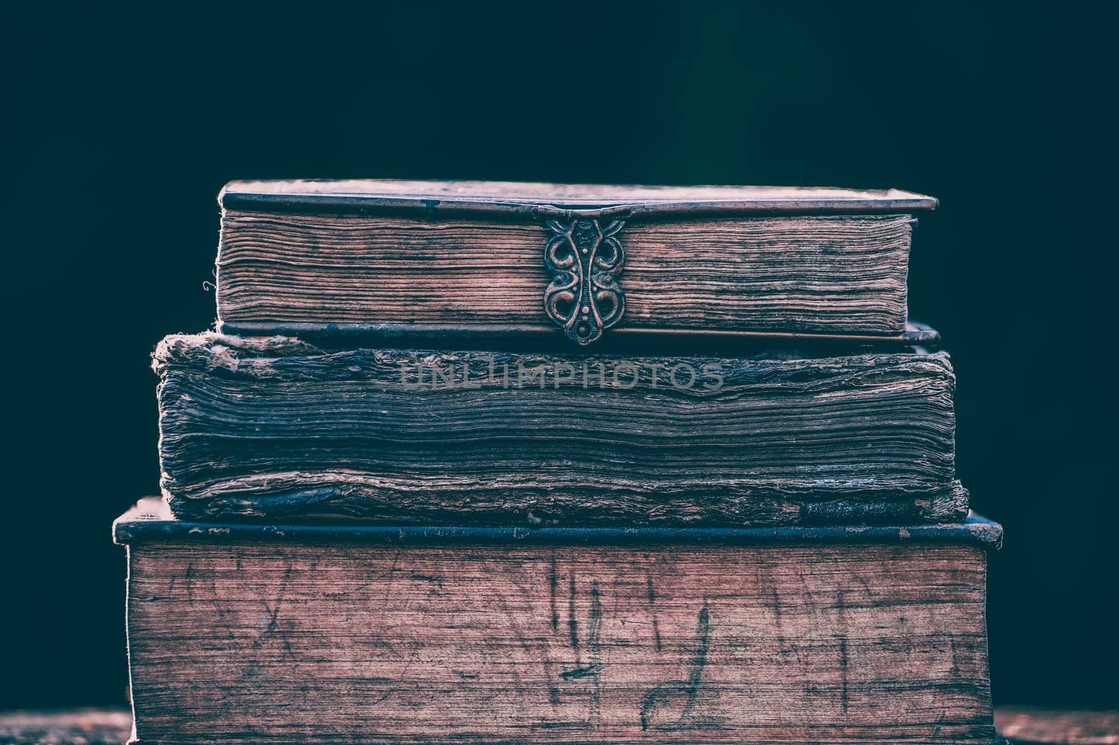 Literature, reading concept: banner or header image with stack of antique books against a dark background