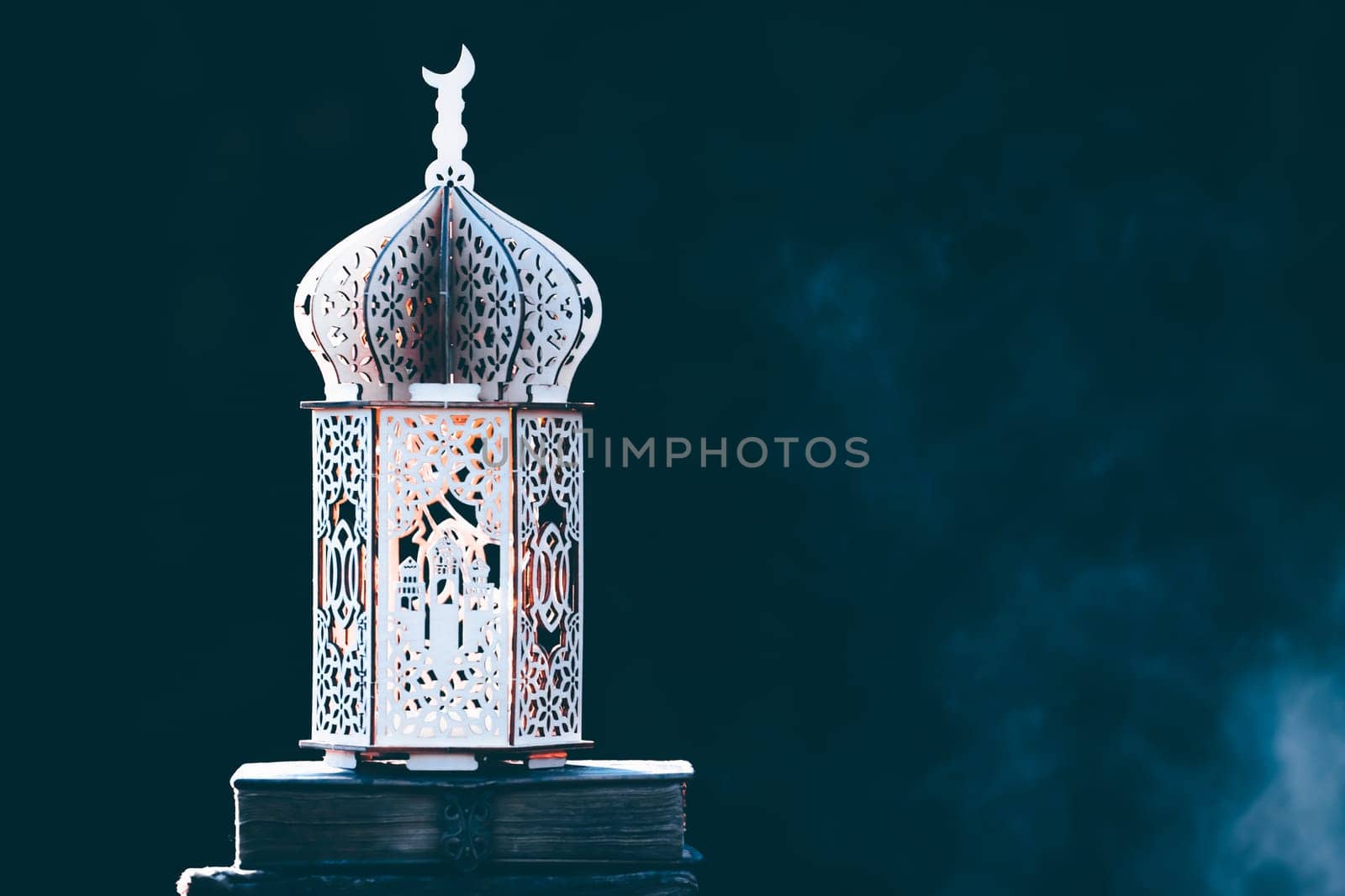 Ornamental Arabic lantern with with Holy Quran. Festive greeting card for Muslim holy month Ramadan Kareem.