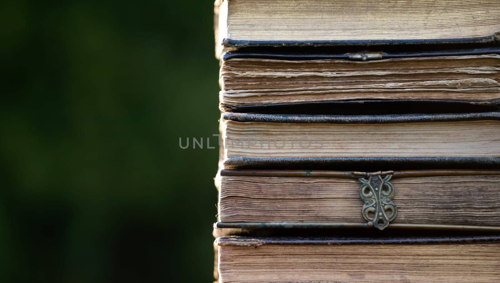 Literature, reading concept: banner or header image with stack of antique books against a dark background