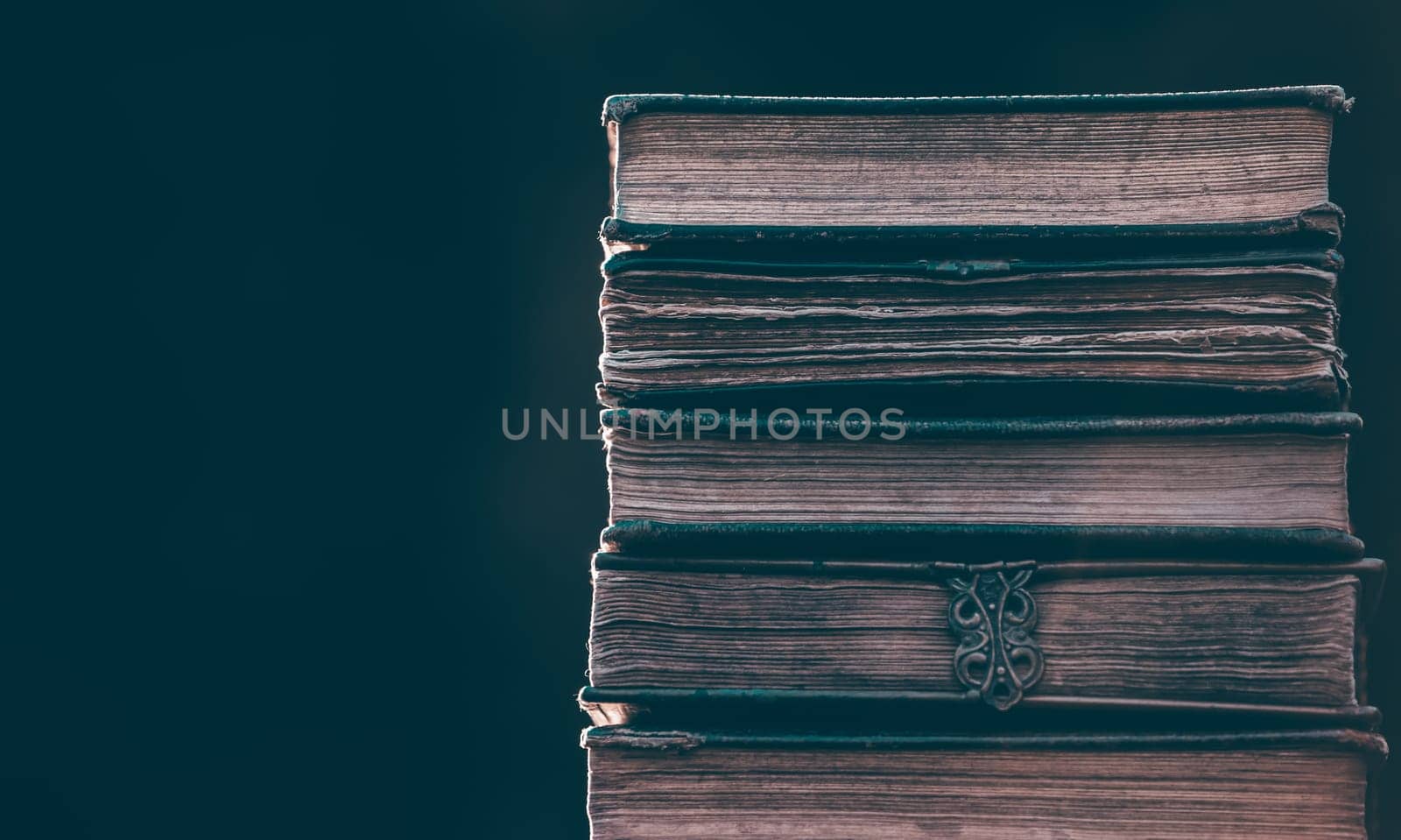 Literature, reading concept: banner or header image with stack of antique books against a dark background