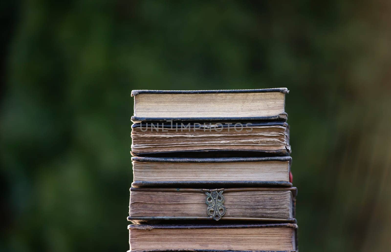 Literature, reading concept: banner or header image with stack of antique books against a dark background