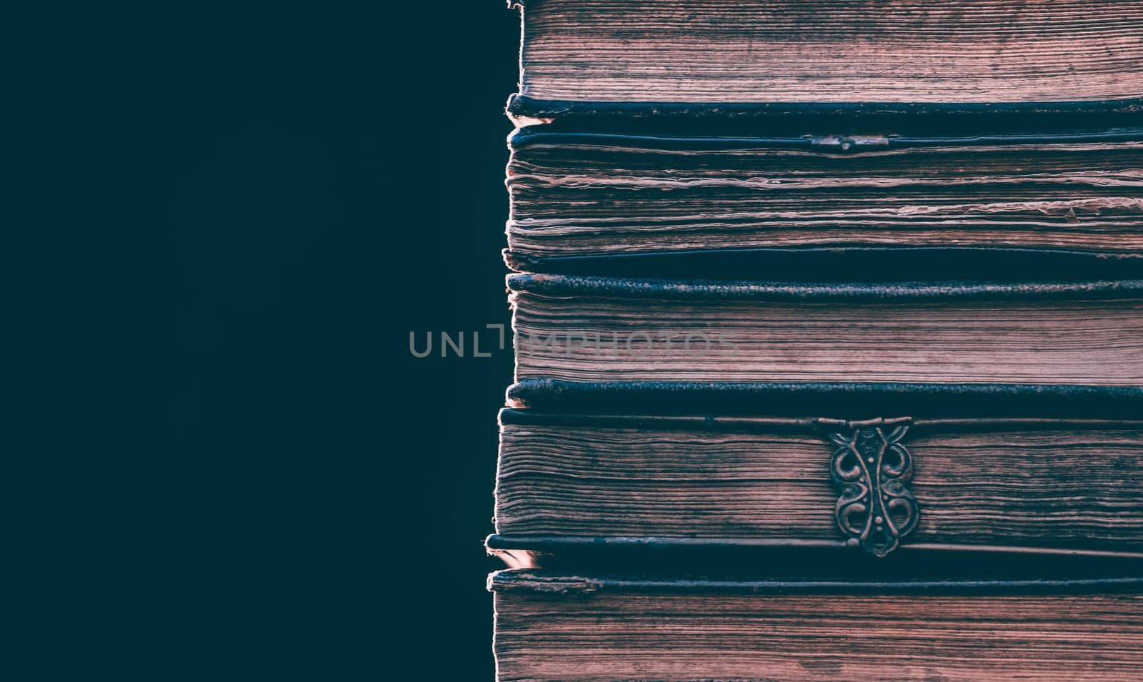 Literature, reading concept: banner or header image with stack of antique books against a dark background
