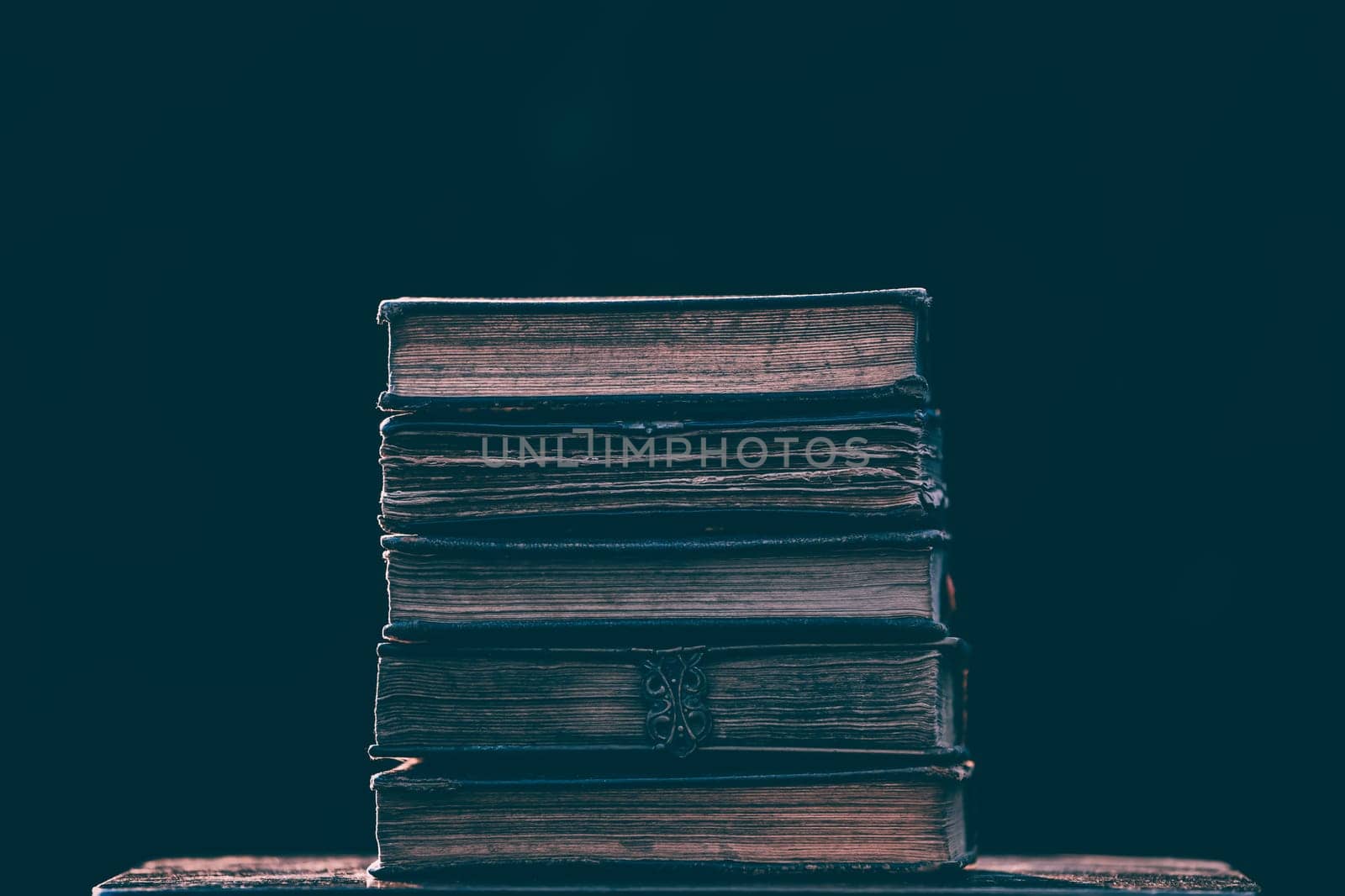 Literature, reading concept: banner or header image with stack of antique books against a dark background