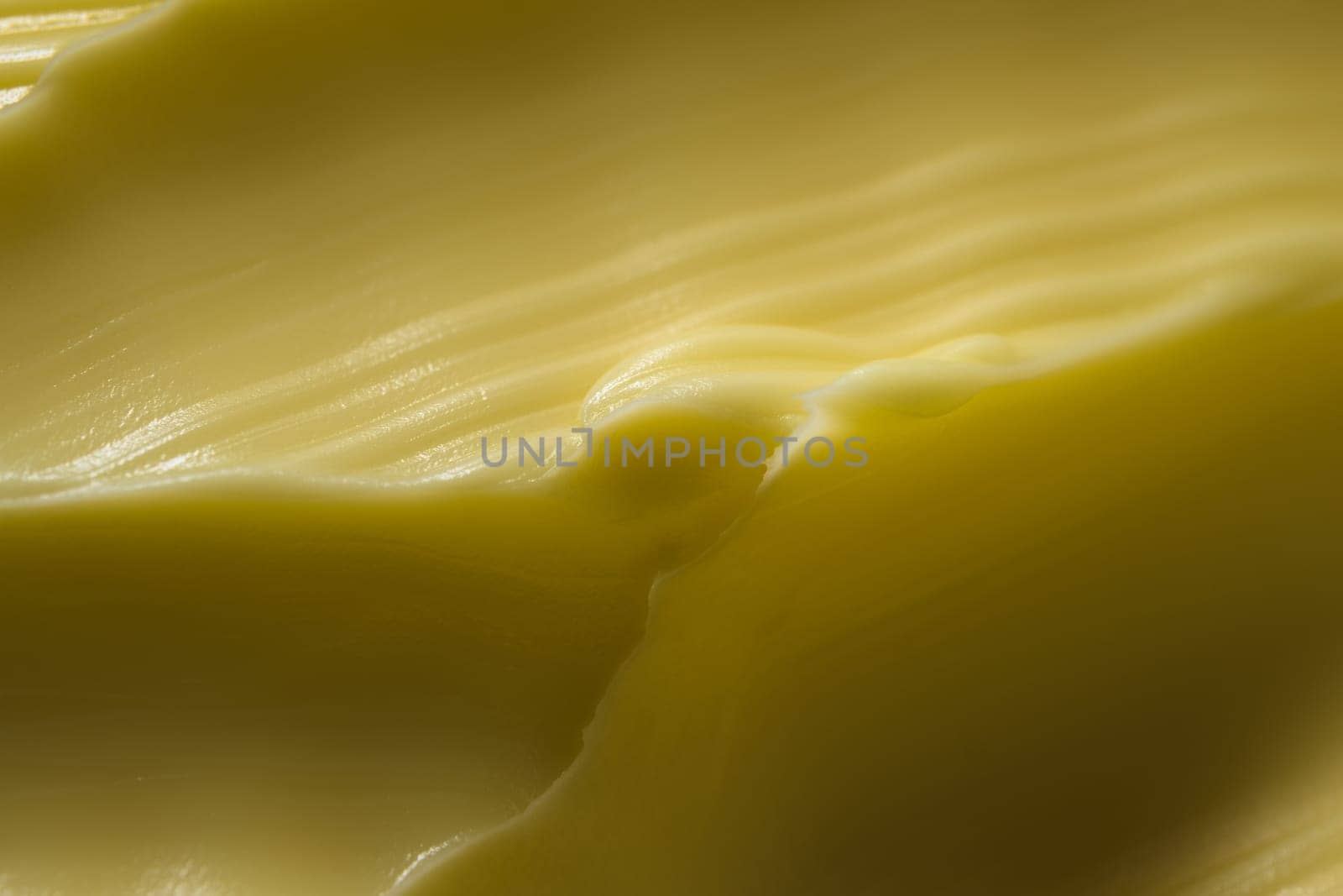 Super macro wavy margarine pattern. A common kitchen ingredient that is often touted as a healthier alternative to butter. Spreadable and yellow color