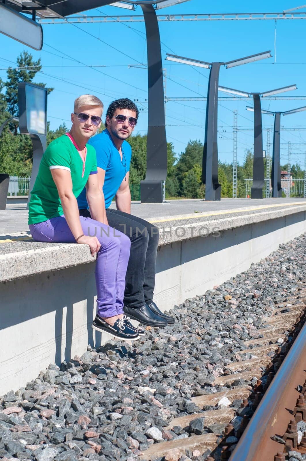 Shot of two young men sitting on platform.