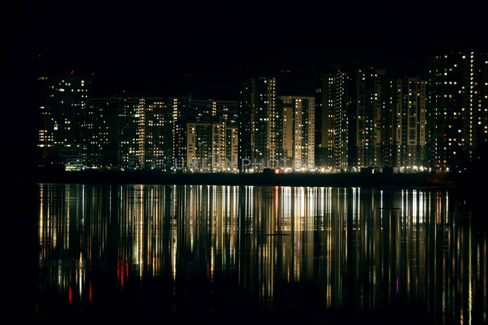 skyscrapers are reflected in the river at night cityscape
