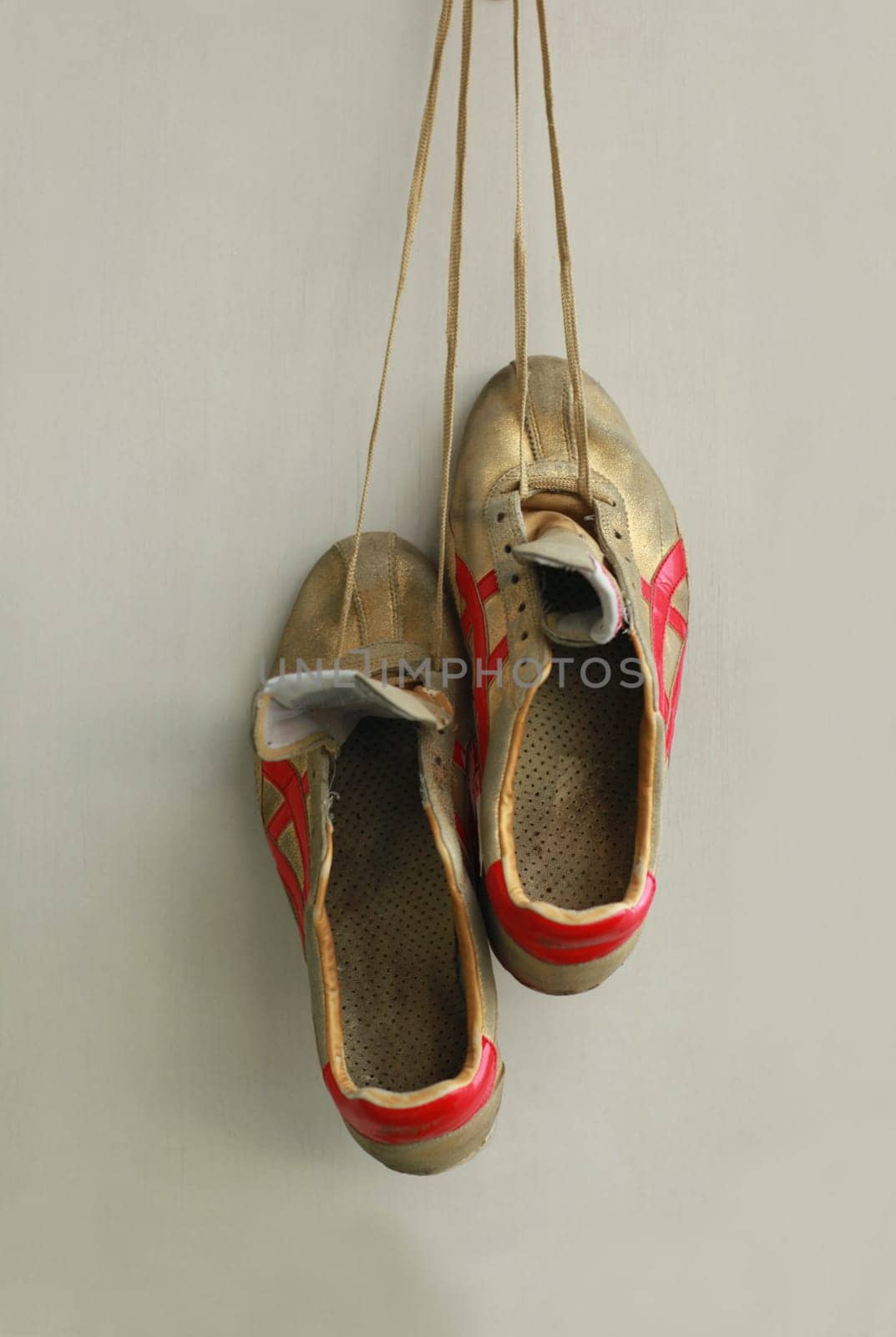 Champion gold sneakers, hanging on laces