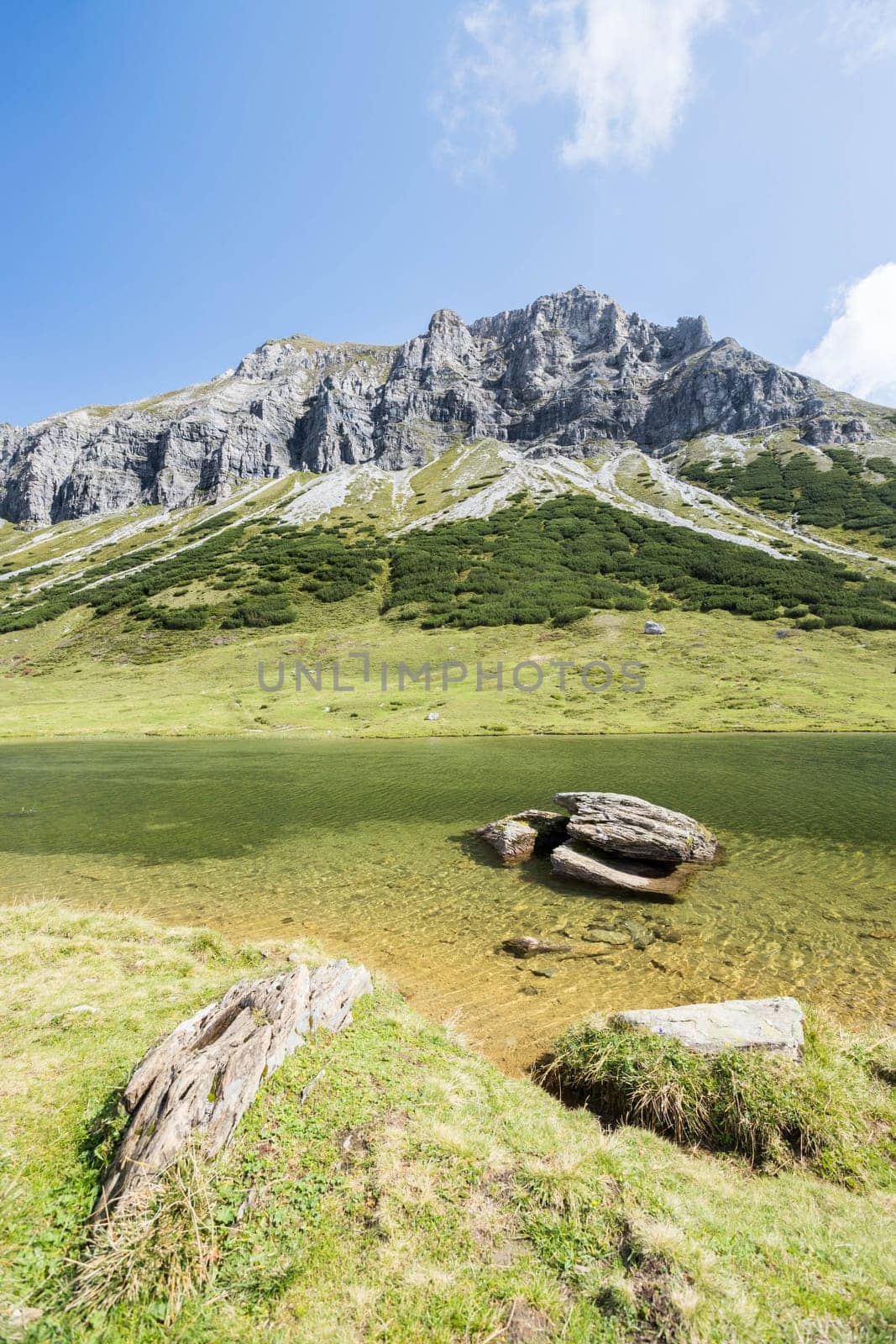 Lake with clear water in the foreground, rugged mountains in the background