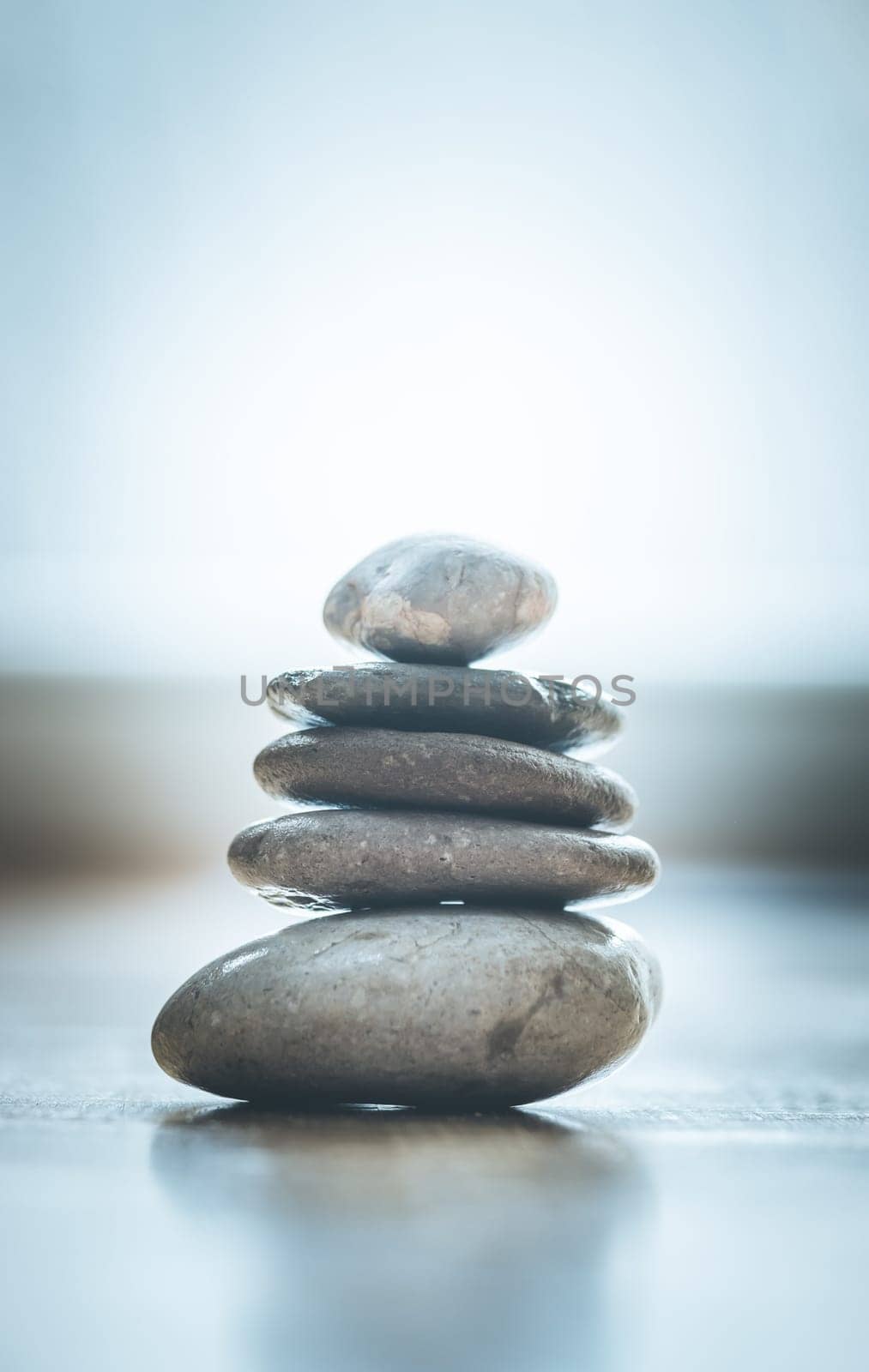 Feng Shui: Stone cairn on the wooden floor, text space and cool light