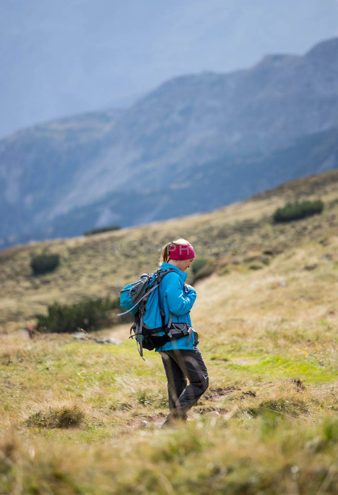 Woman in professional sportswear is hiking on the mountain, Austria