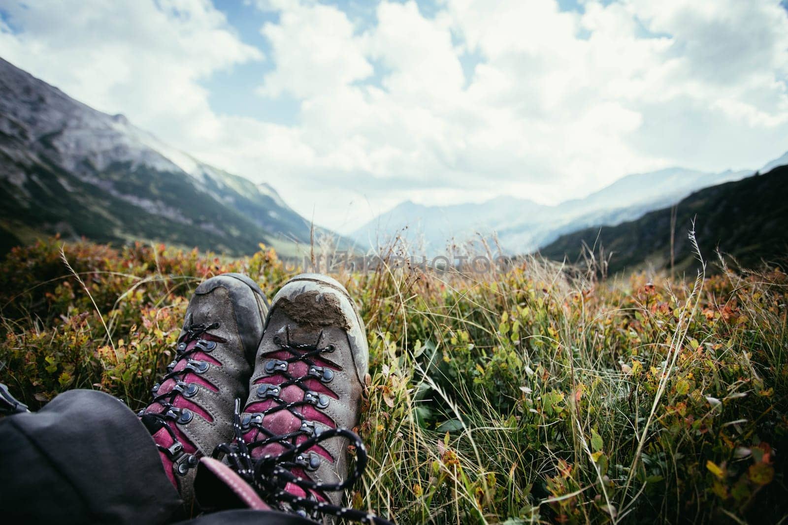 Cut out of a woman in hiking boots who is enjoying the idyllic mountain landscape