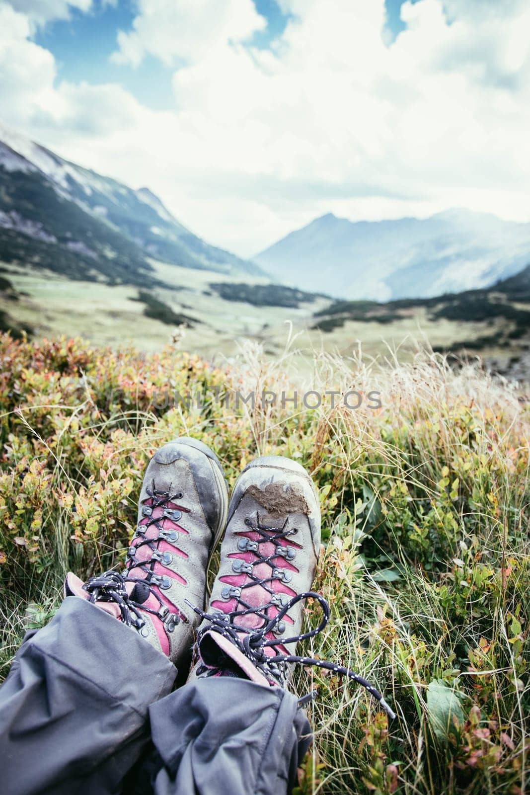 Cut out of a woman in hiking boots who is enjoying the idyllic mountain landscape