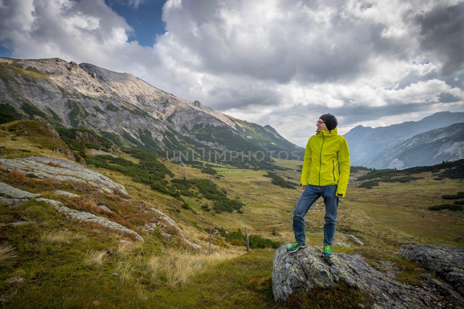 Male mountain climber with backpack is enjoying the view
