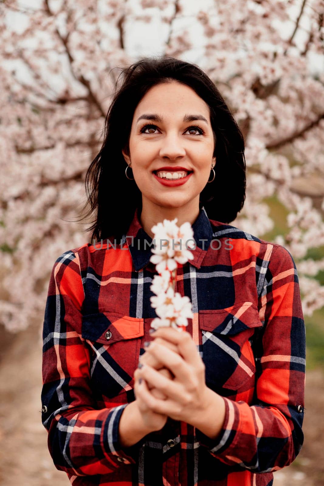 Brunette girl near a almond tree with many flowers
