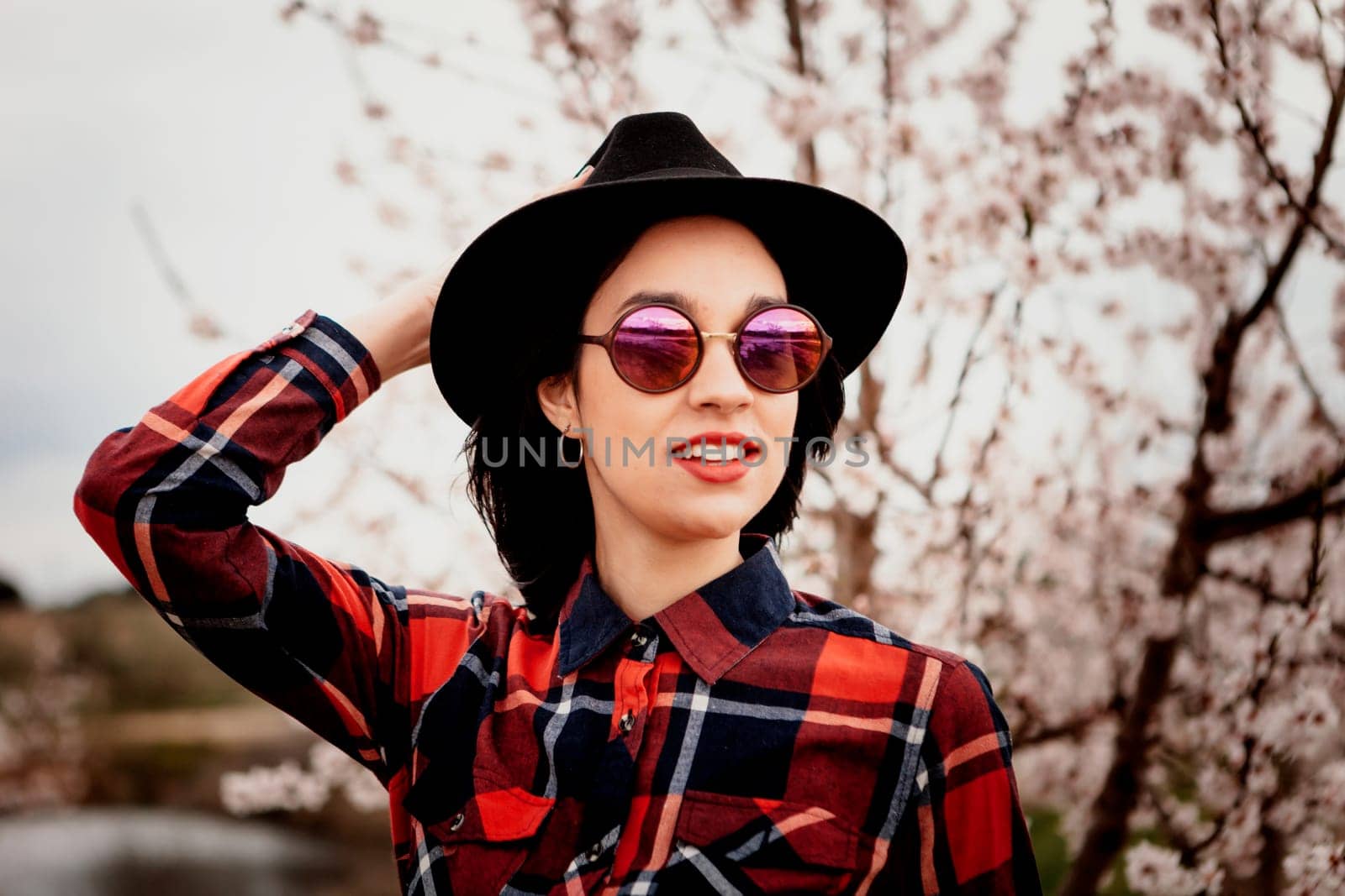 Brunette girl near a almond tree with many flowers