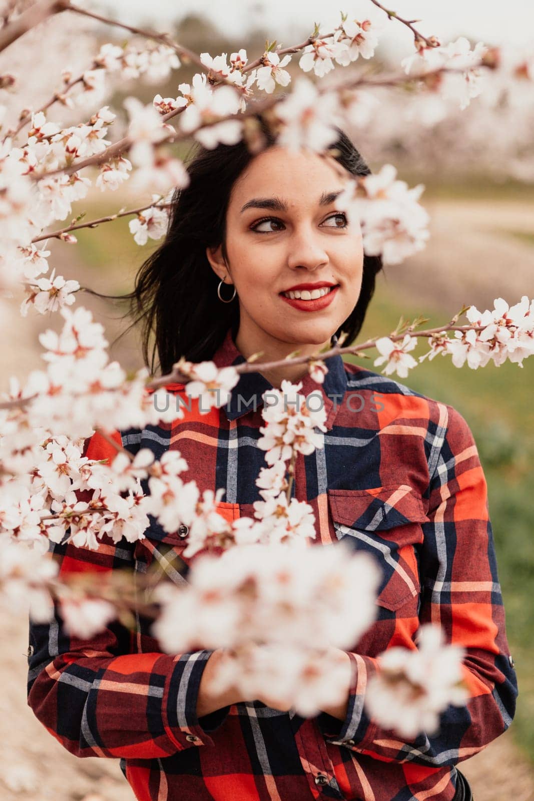 Brunette girl near a almond tree with many flowers