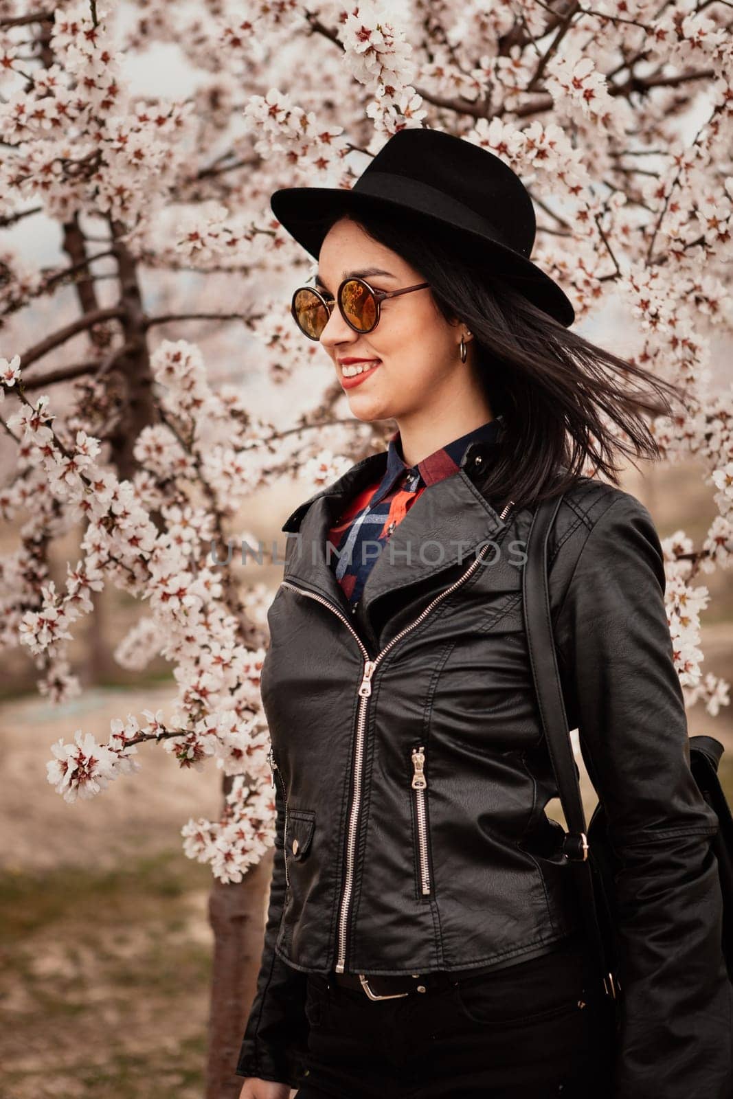 Brunette girl near a almond tree with many flowers