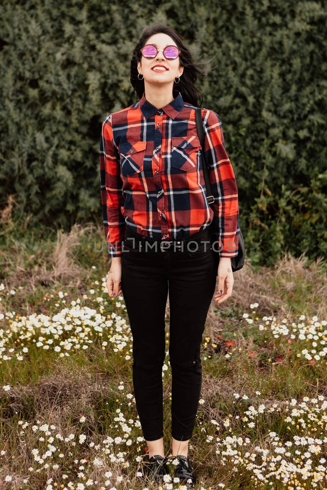 Pretty brunette girl with red plaid shirt in the park