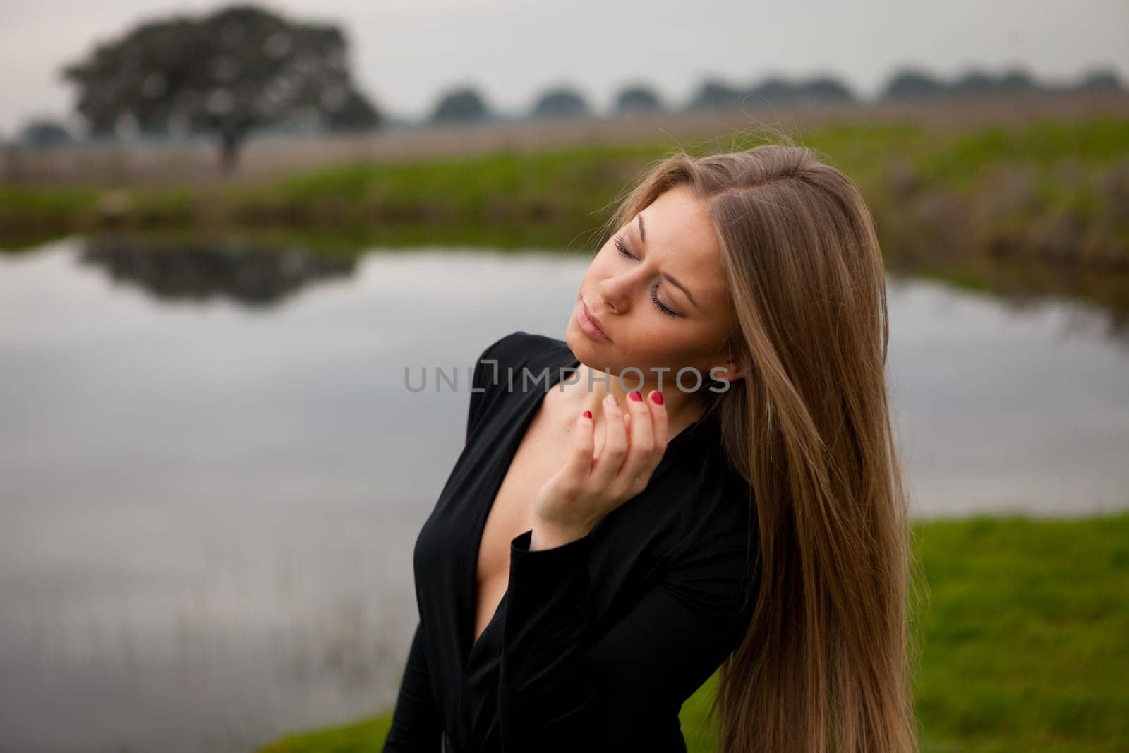Attractive girl with long hair and sexy black shirt in the field