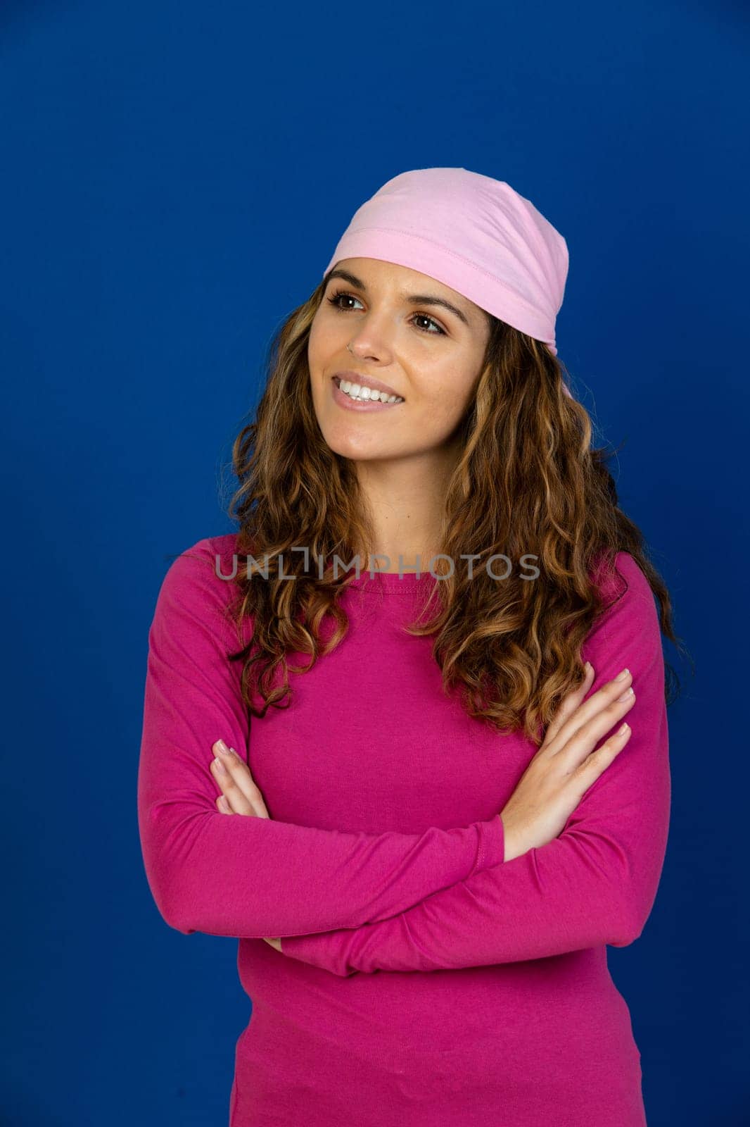 Hopeful woman wearing a pink scarf isolated on a white background