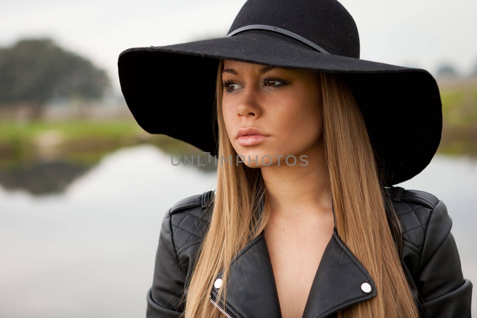 Stylish young woman with beautiful hat with a beautiful landscape of background