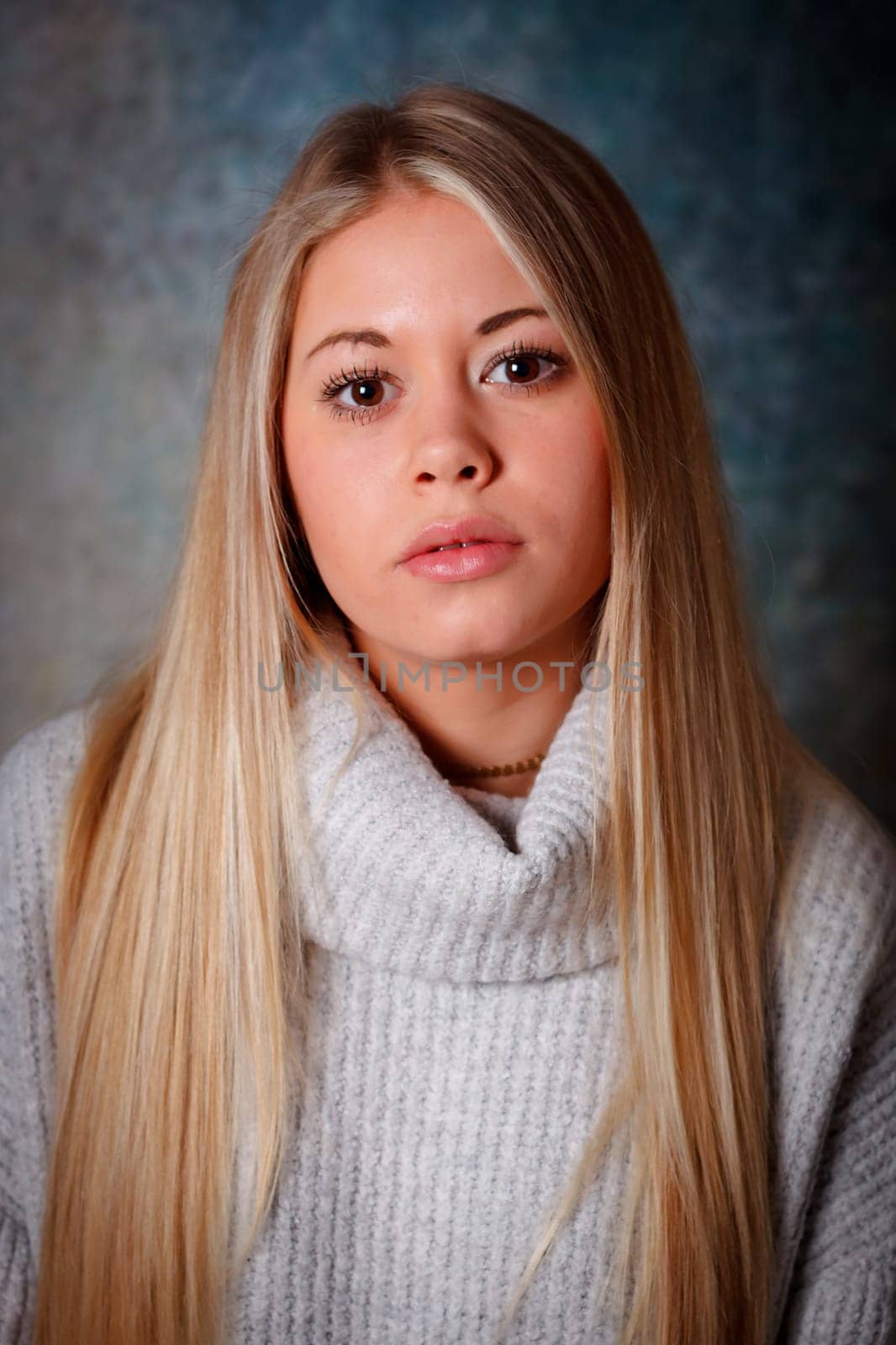 Pretty girl with long blond hair and blue background