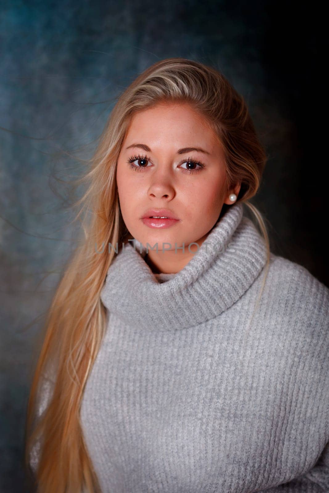Pretty girl with long blond hair and blue background