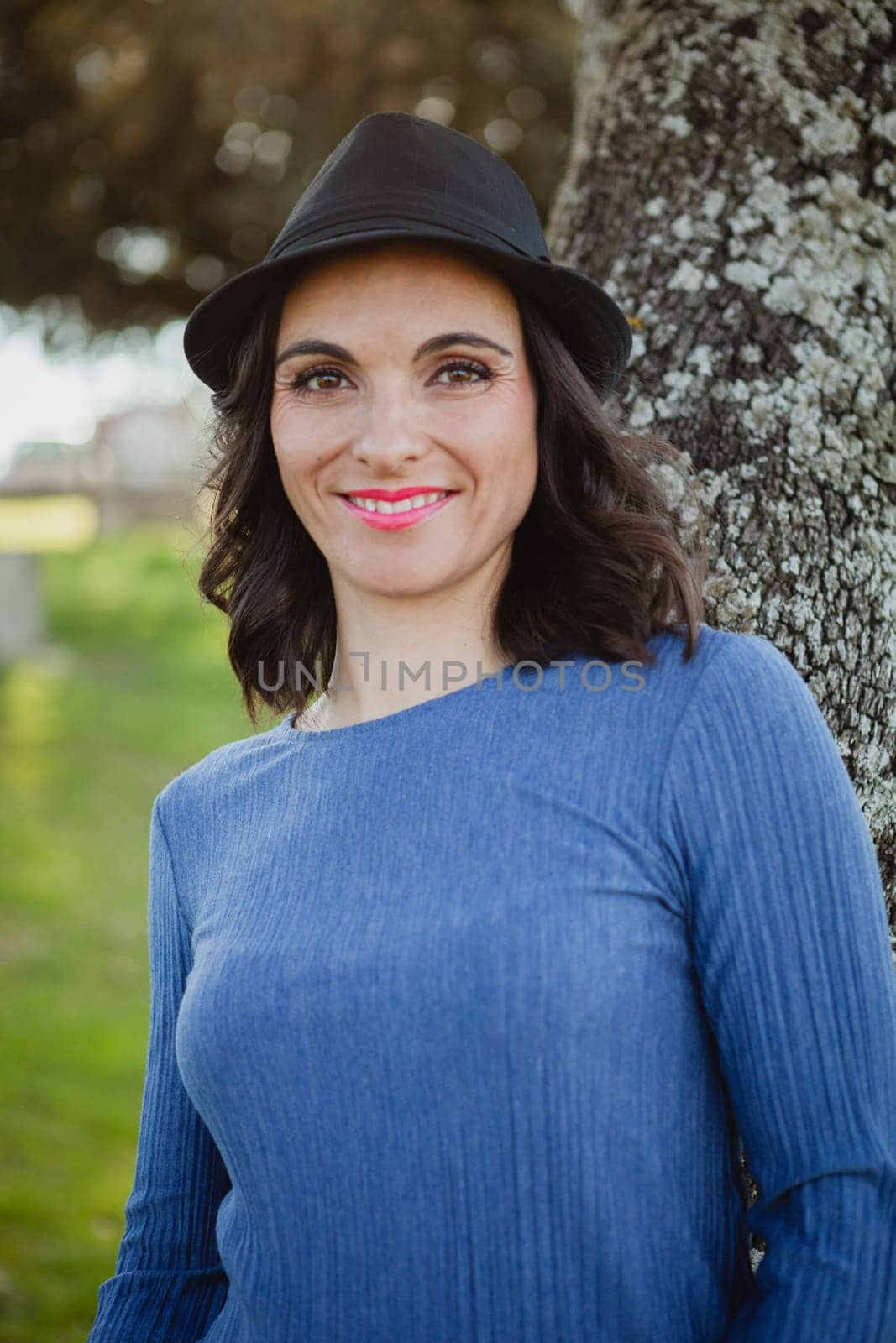 Stylish young woman with black hat in the field