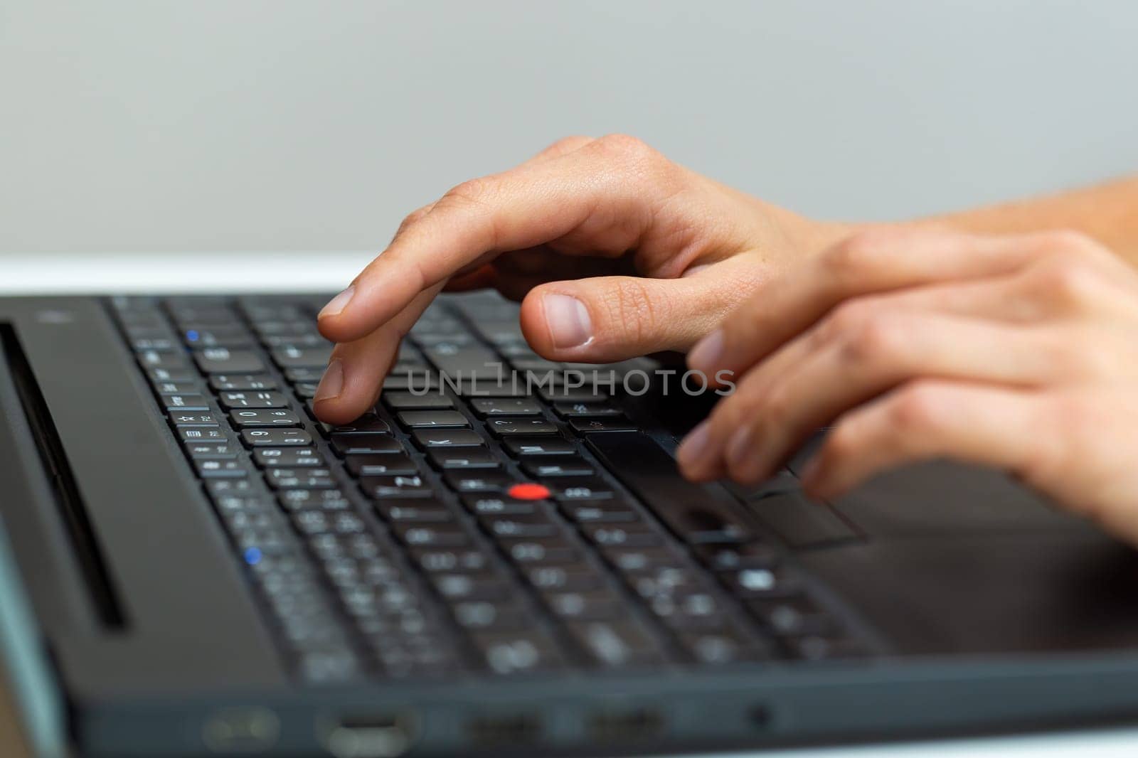 Human hand writting on laptop in office from close up. Bussiness person working on computer in workplace. Surfing on internet through electronic device.