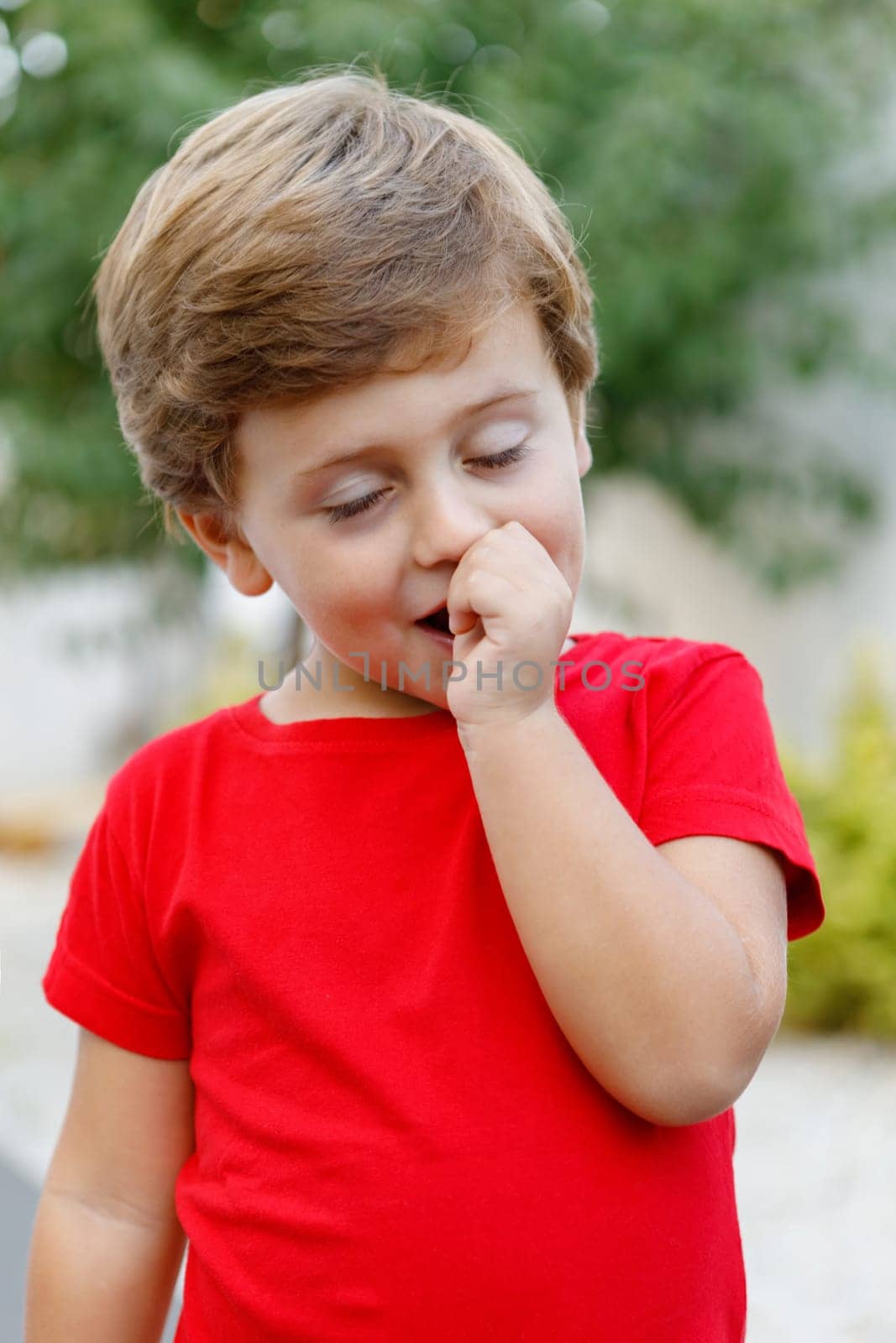 Happy child with red t-shirt playing in the garden
