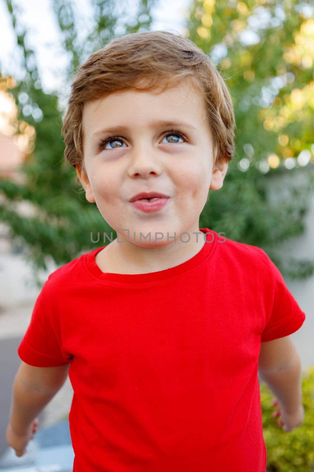Happy child with red t-shirt playing in the garden