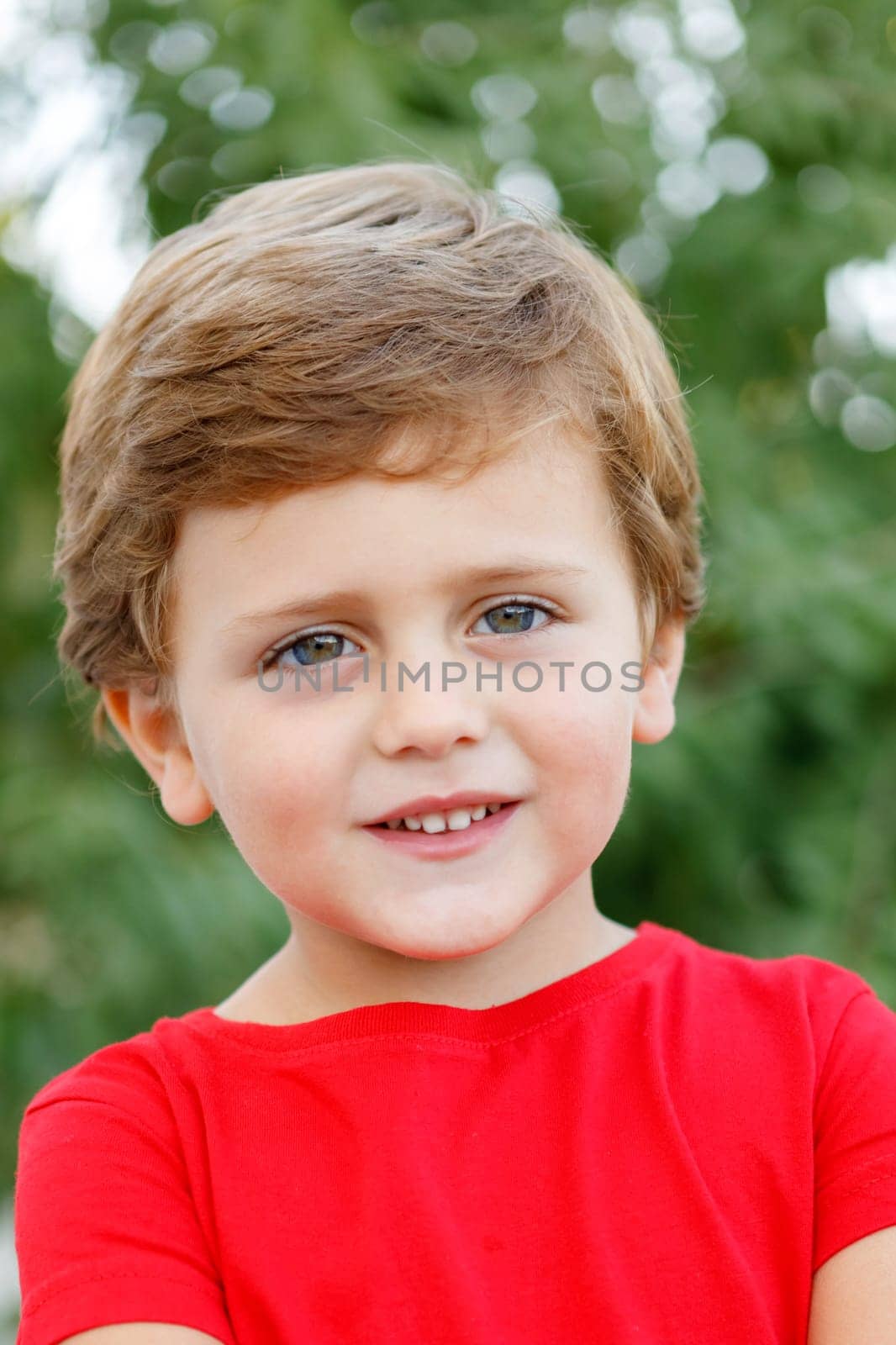 Happy child with red t-shirt playing in the garden