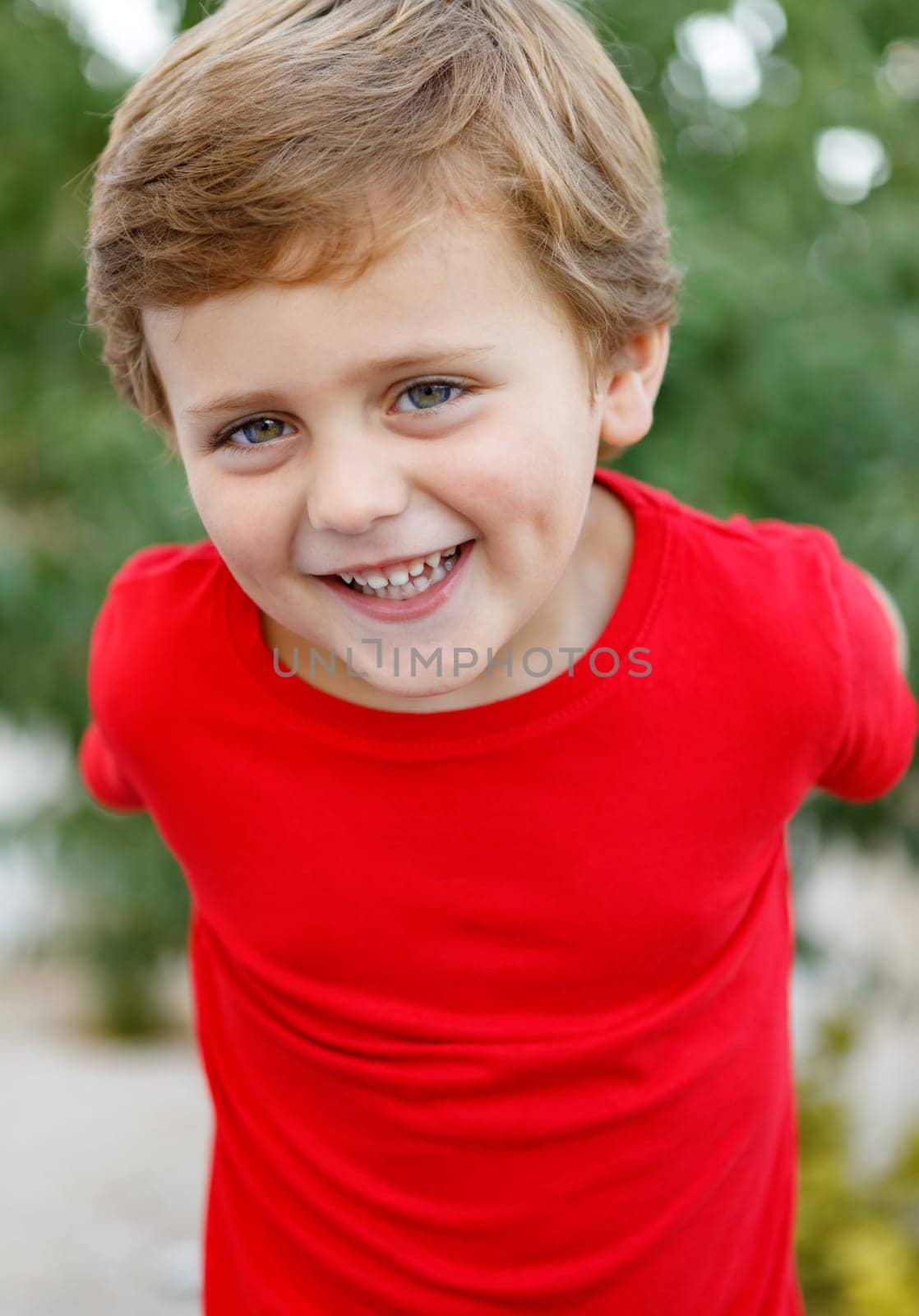Happy child with red t-shirt playing in the garden