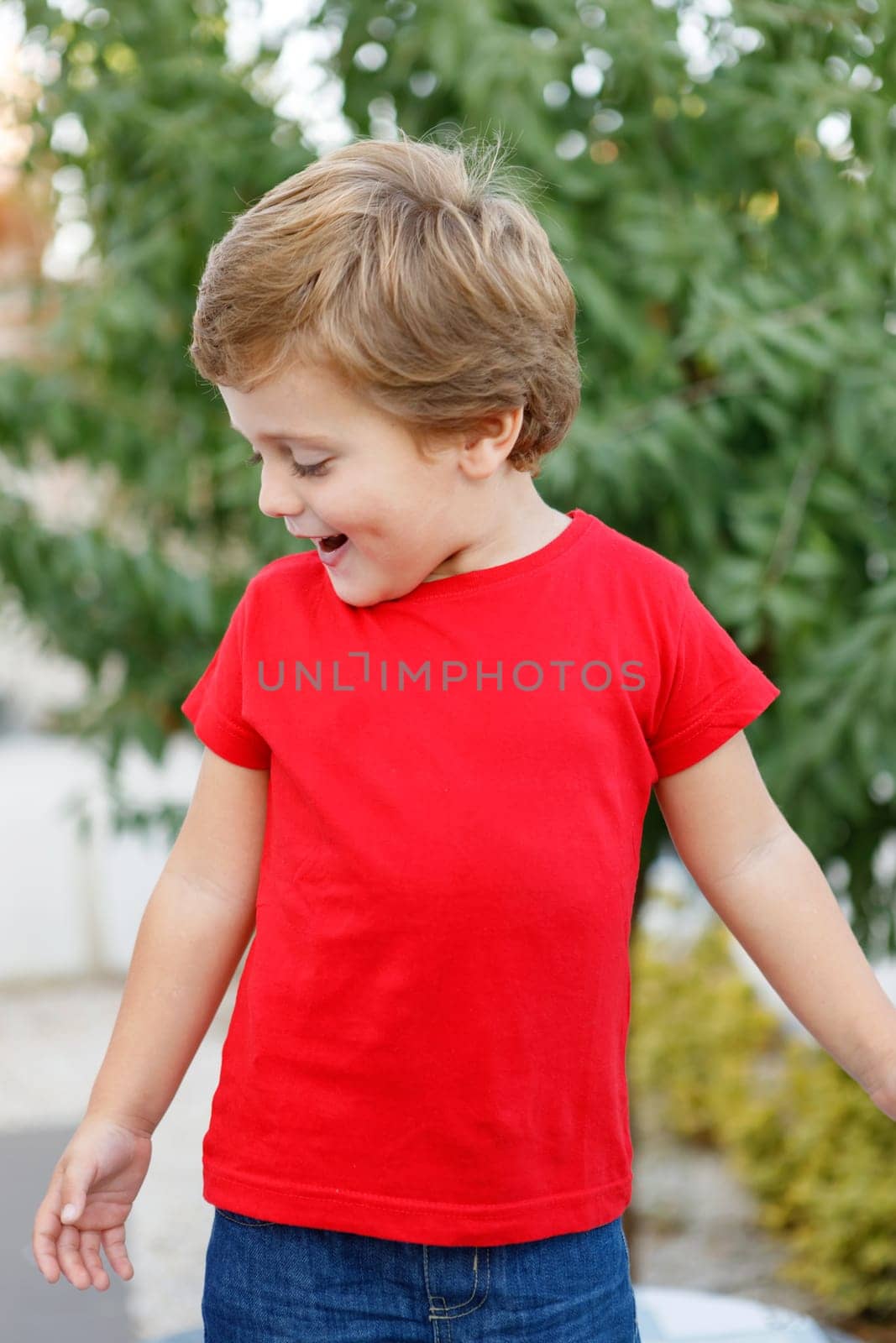 Happy child with red t-shirt playing in the garden