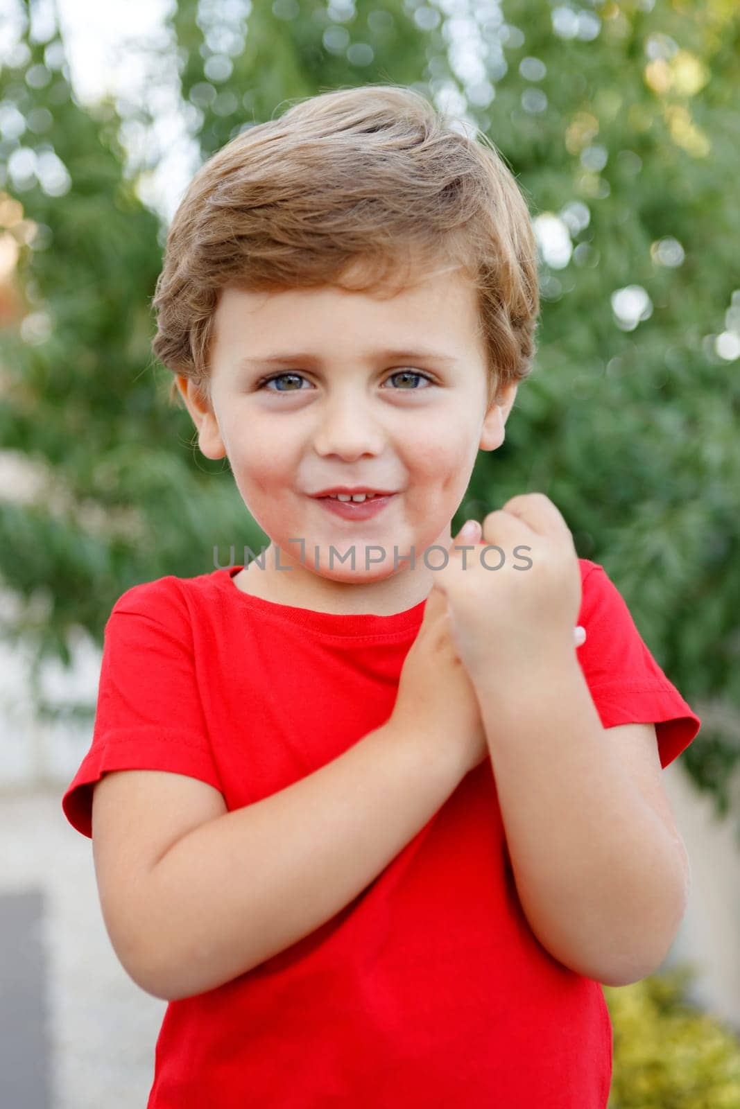 Happy child with red t-shirt playing in the garden