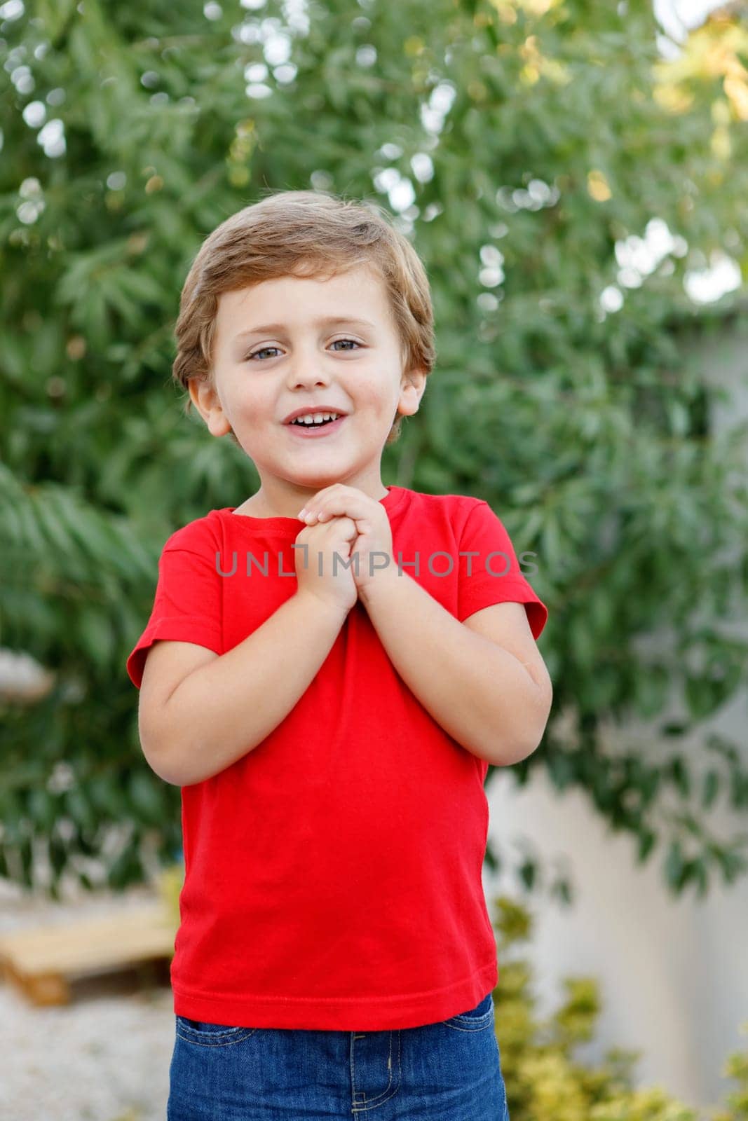 Happy child with red t-shirt playing in the garden