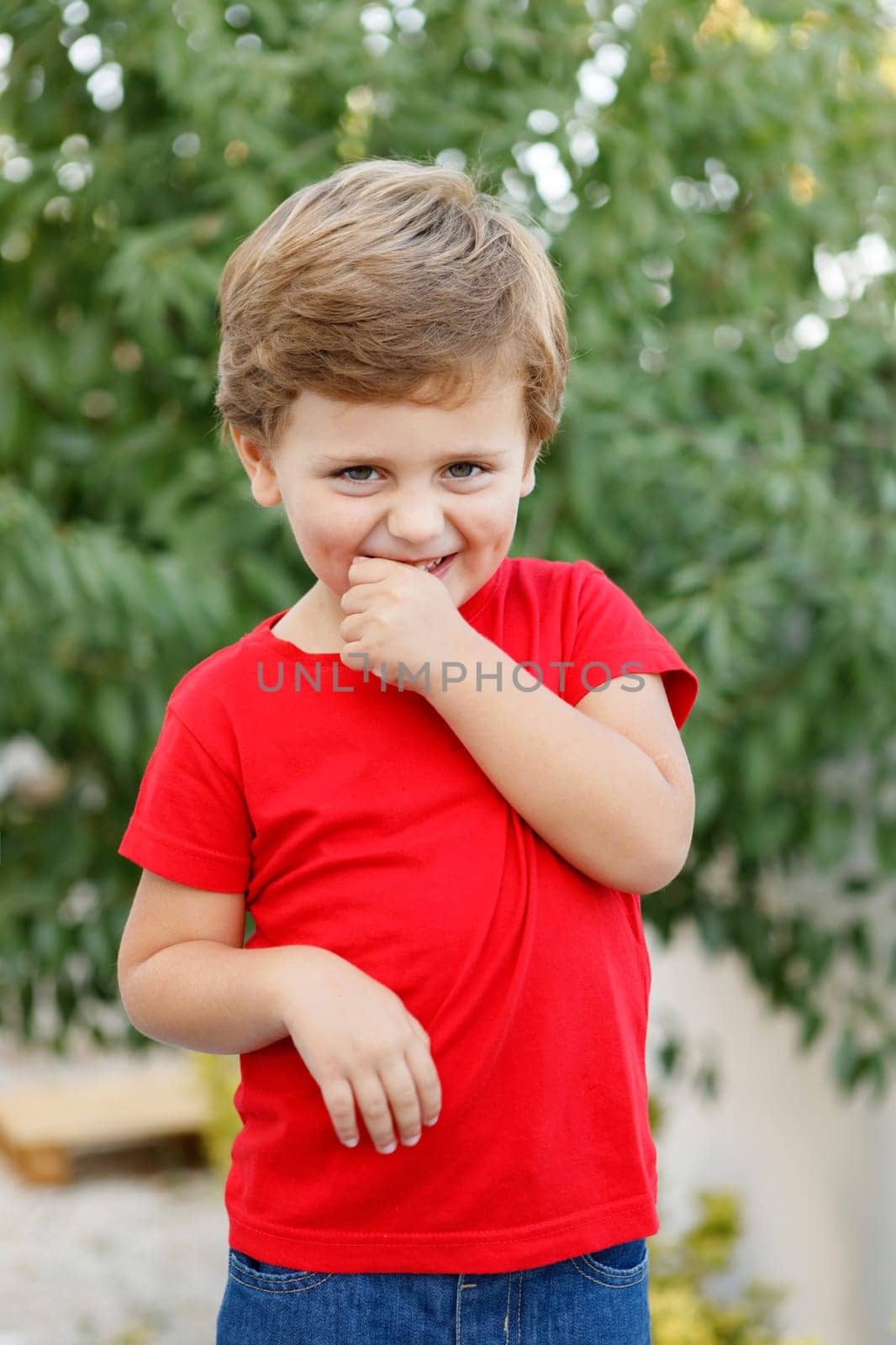 Happy child with red t-shirt playing in the garden