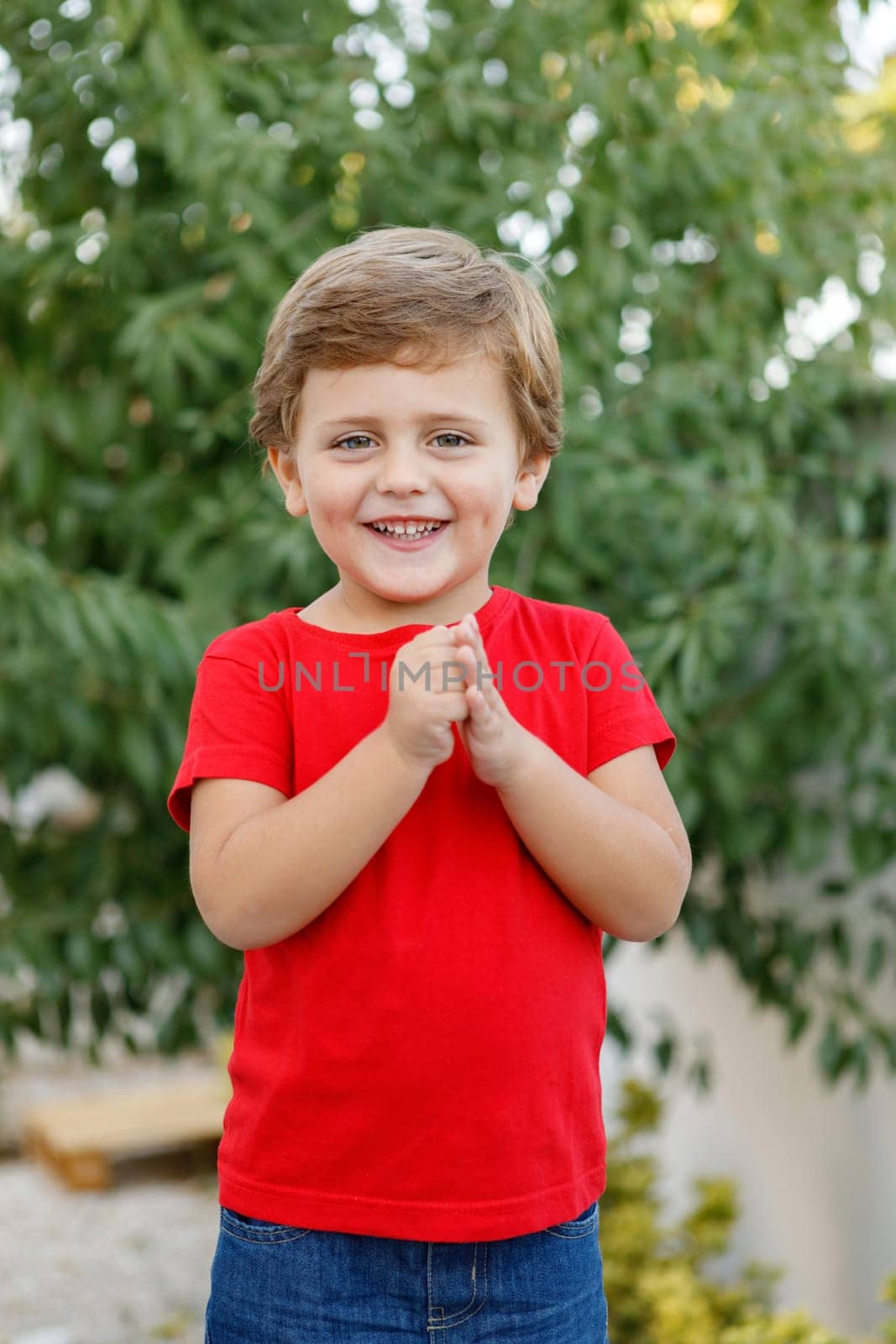 Happy child with red t-shirt playing in the garden