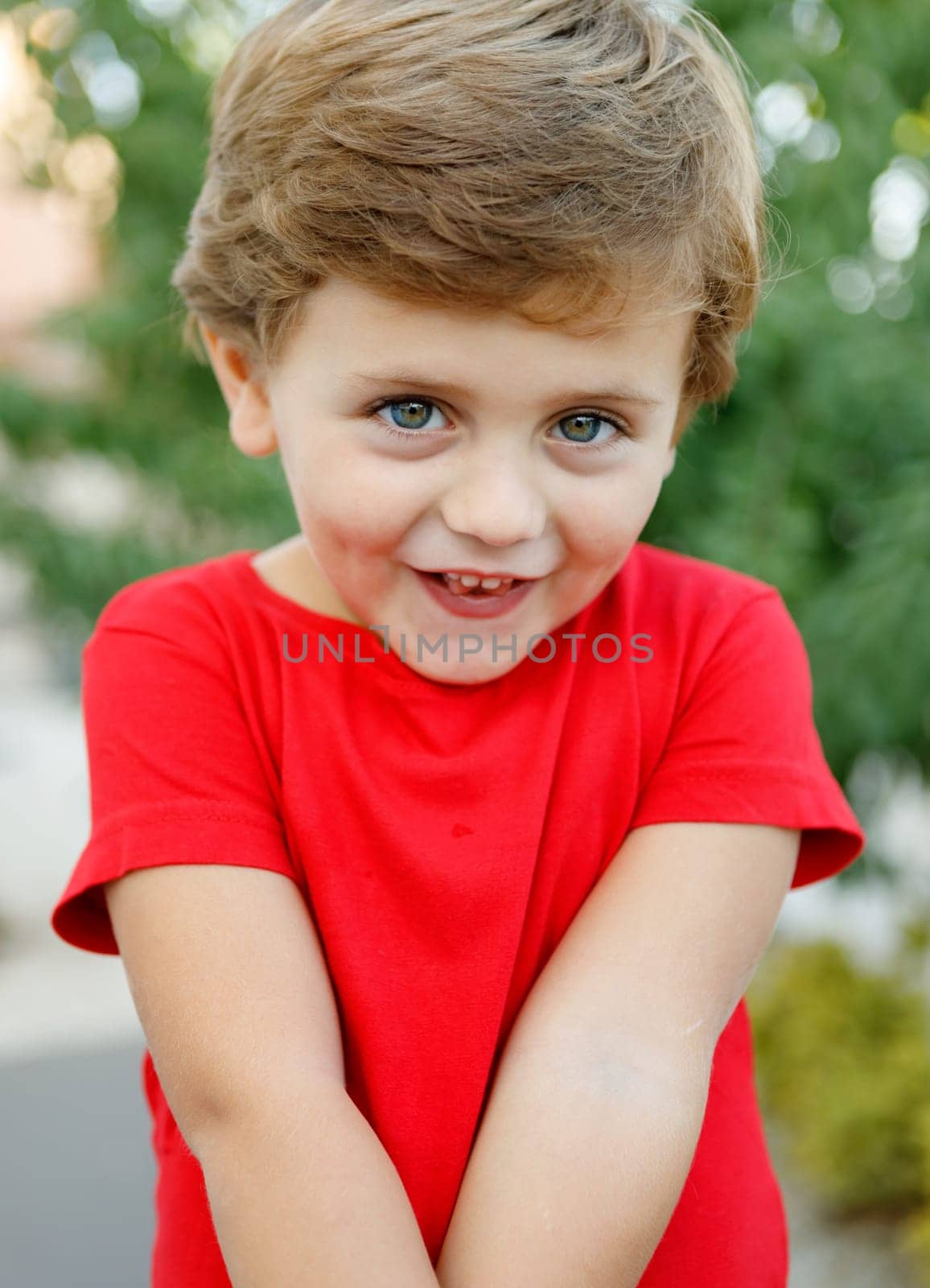 Happy child with red t-shirt playing in the garden