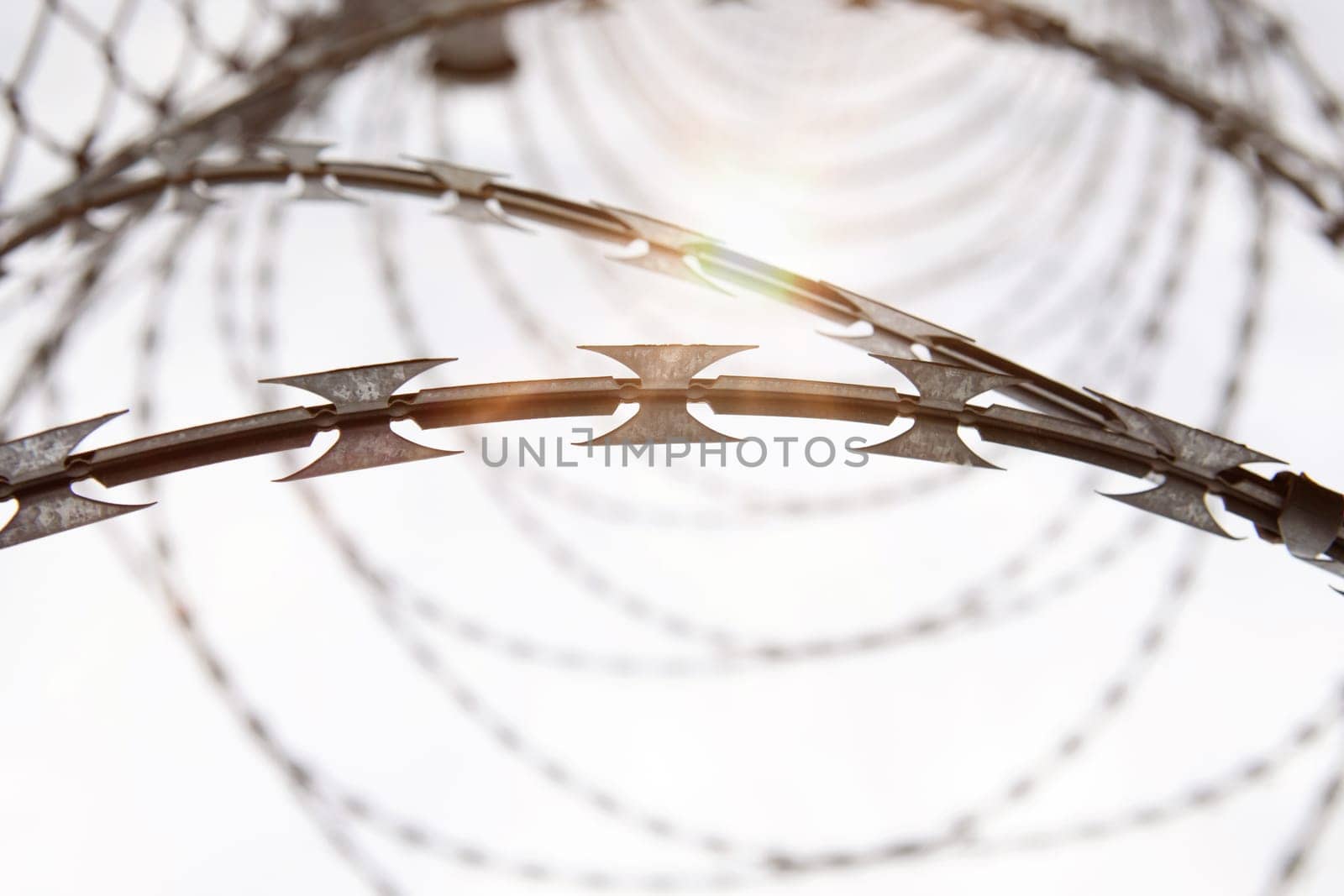 Fence with a barbed wire under a blue sky